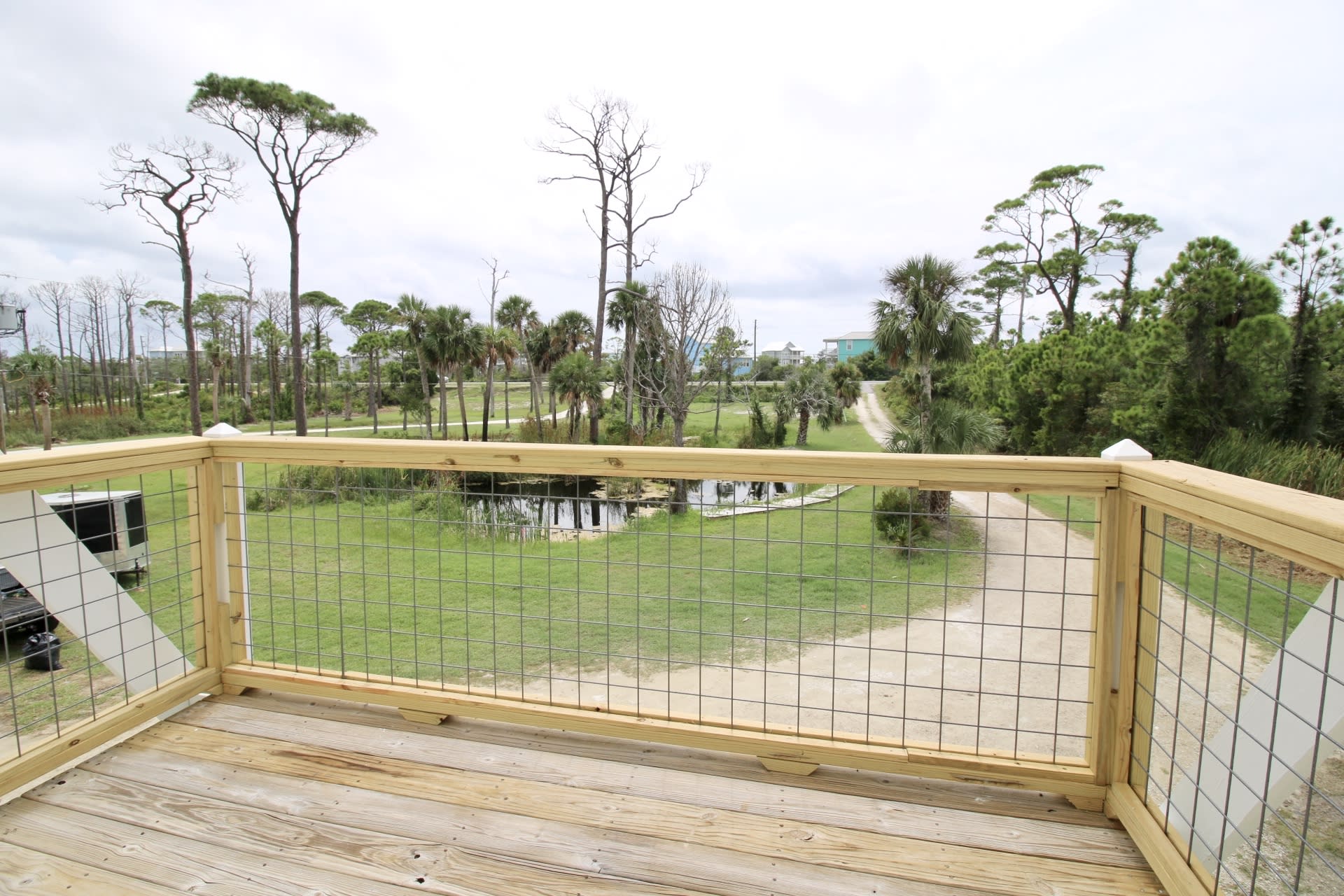 Deck on front of home overlooking front yard pond and driveway leading to CSB Rd
