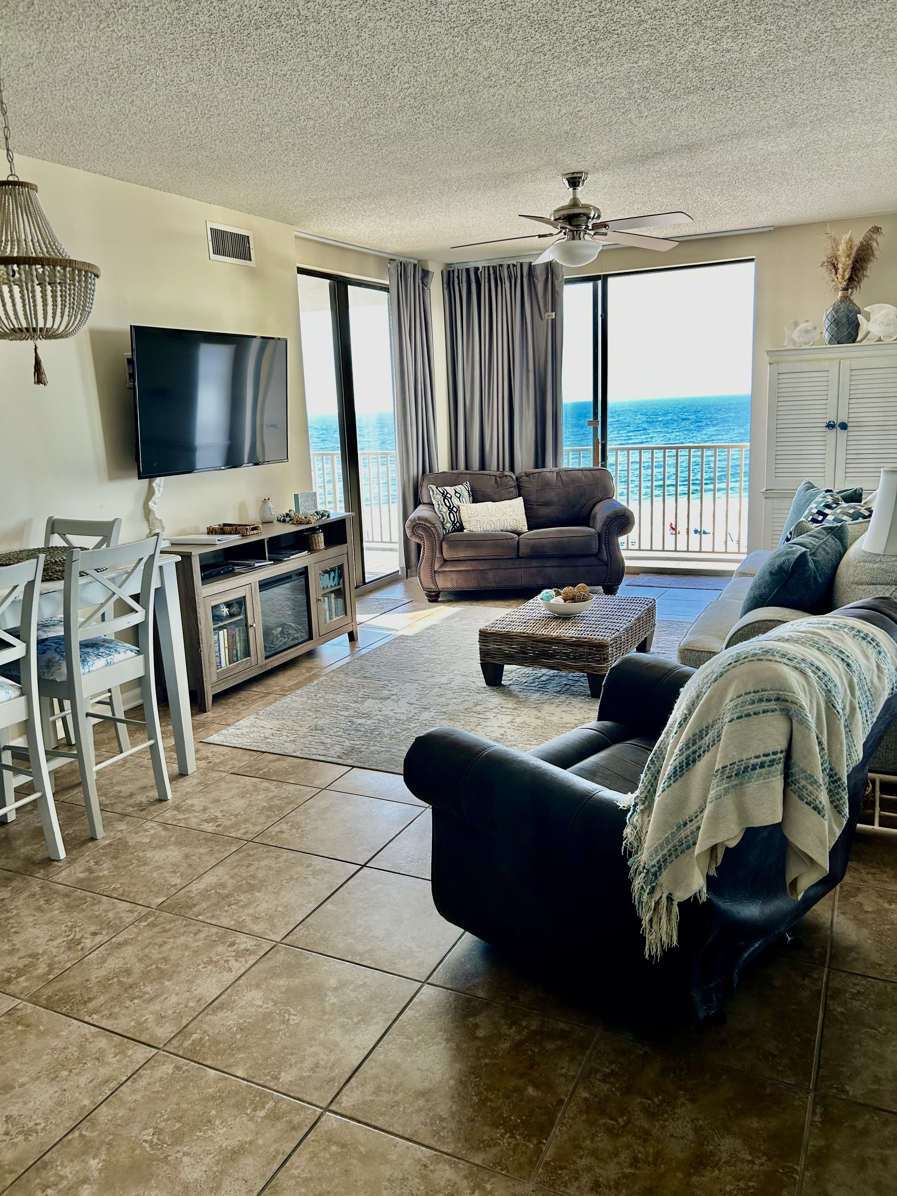 Living and dining area with two sets of sliding glass doors leading to balcony