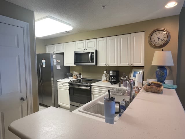 behind frig -- is sitting area with fullsize w/d and big beach window view 