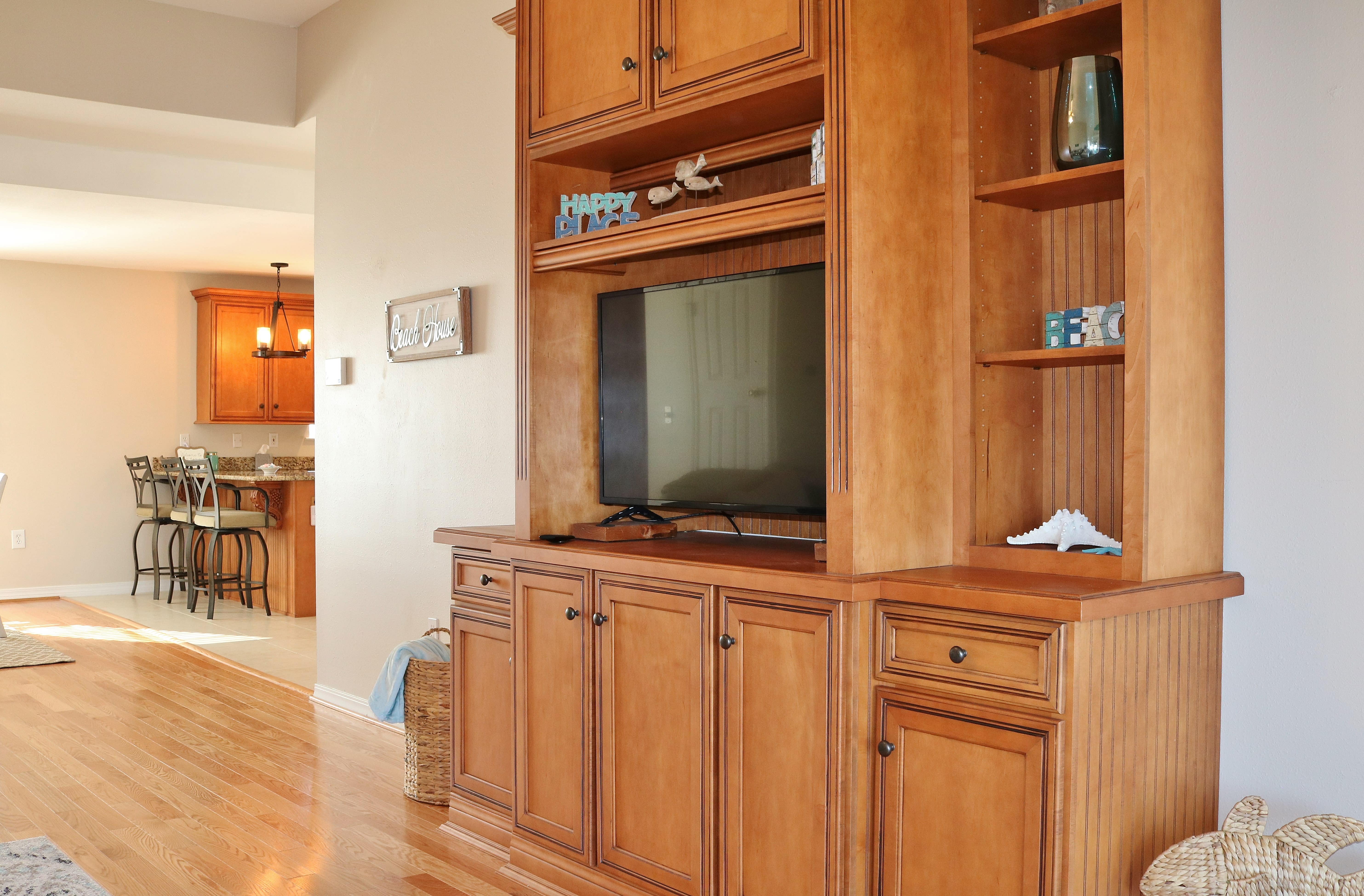 The living room features a built-in entertainment center with smart tv.