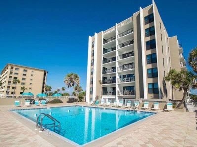 View of the pool from lounge chair. There are picnic tables with shade also. 