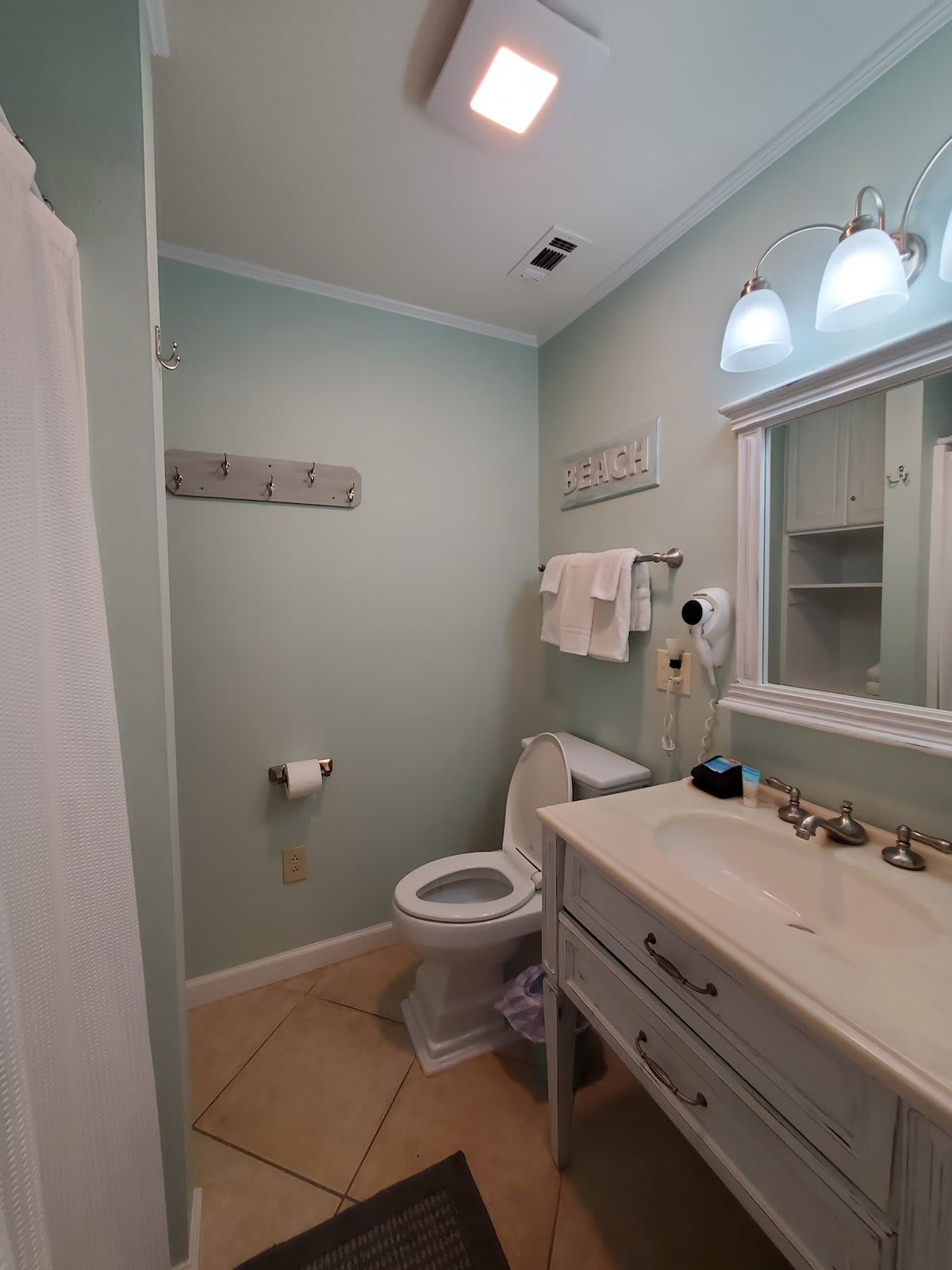 Master bath with shower, hair dryer, and shelves for toiletries.