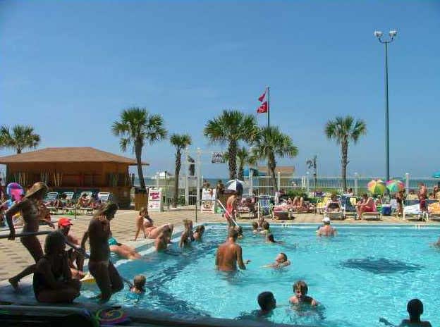 ocean front large pools with beach chairs and umbrella