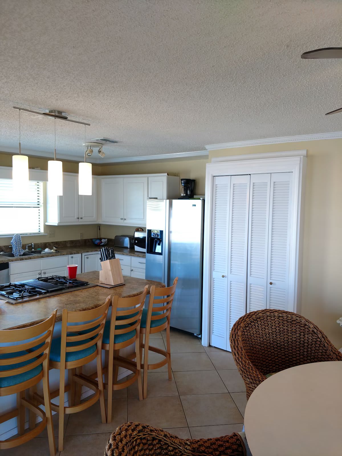 The light, airy kitchen is fully stocked with dishes, utensils, pots and pans.