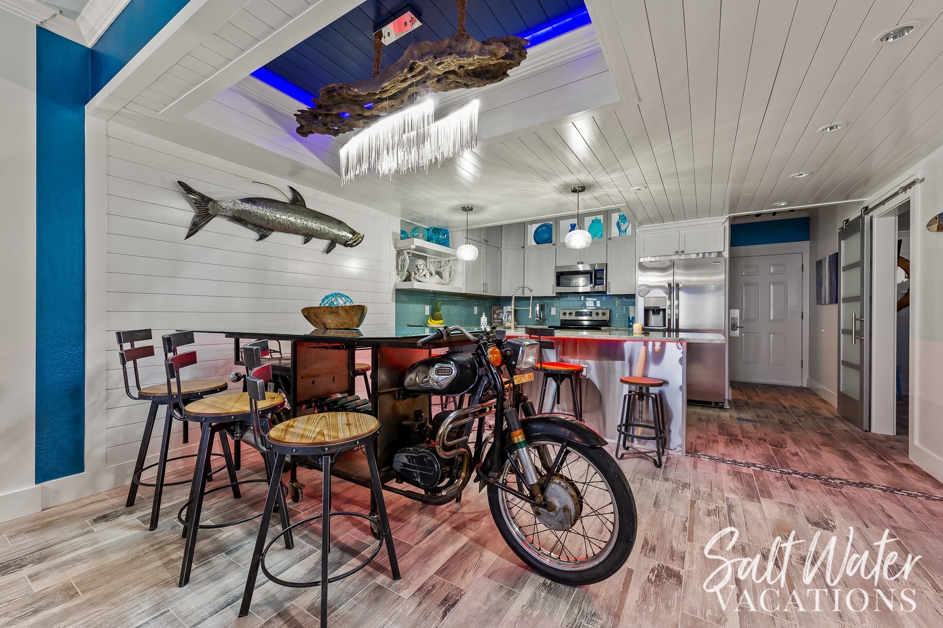 Unique driftwood chandelier with LED lighting above motorcycle dining table