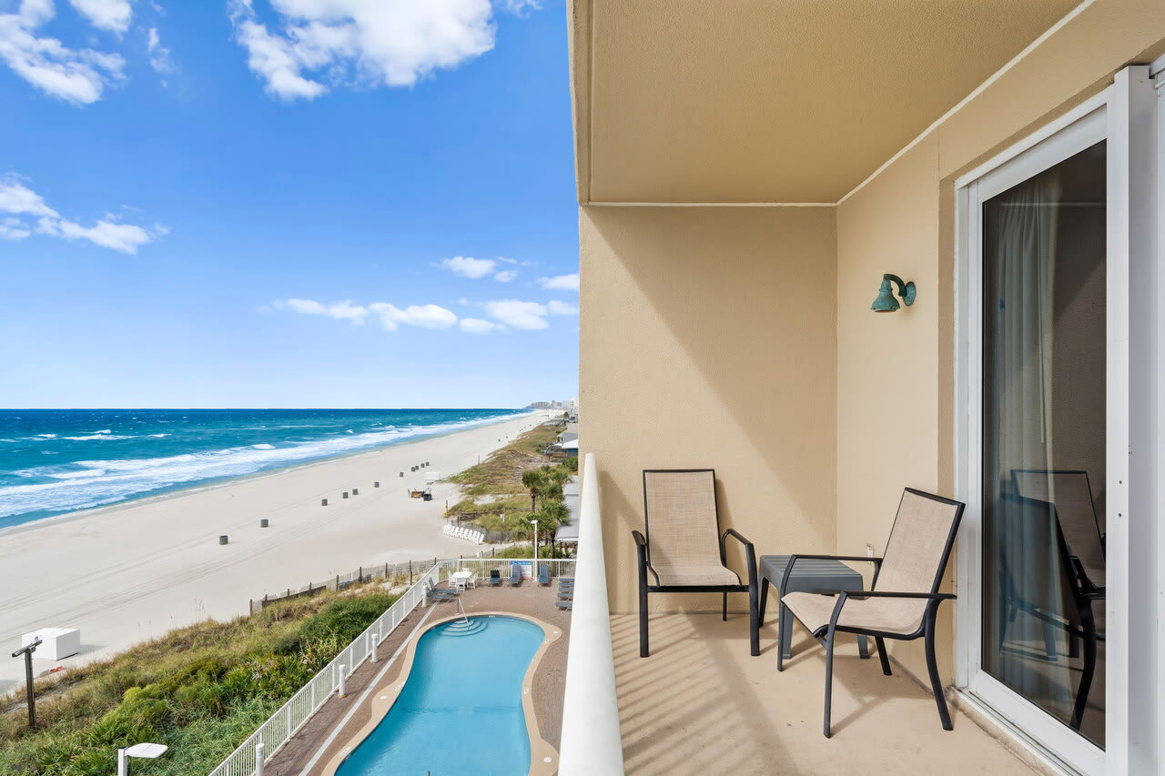Private beachfront balcony overlooking resort pool, white sand beach, and Gulf views