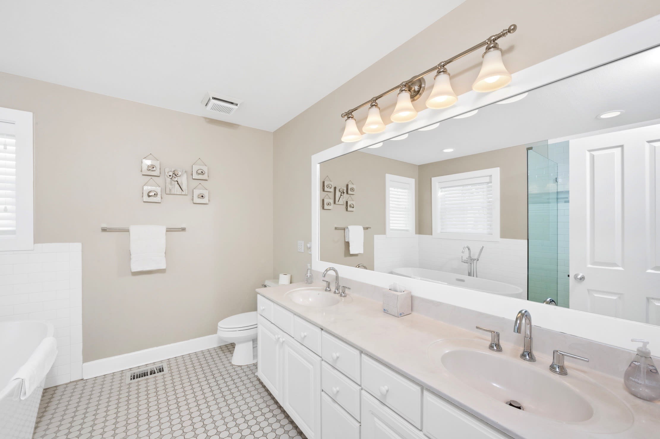 Spacious master bath with dual vanity sinks and large mirror.