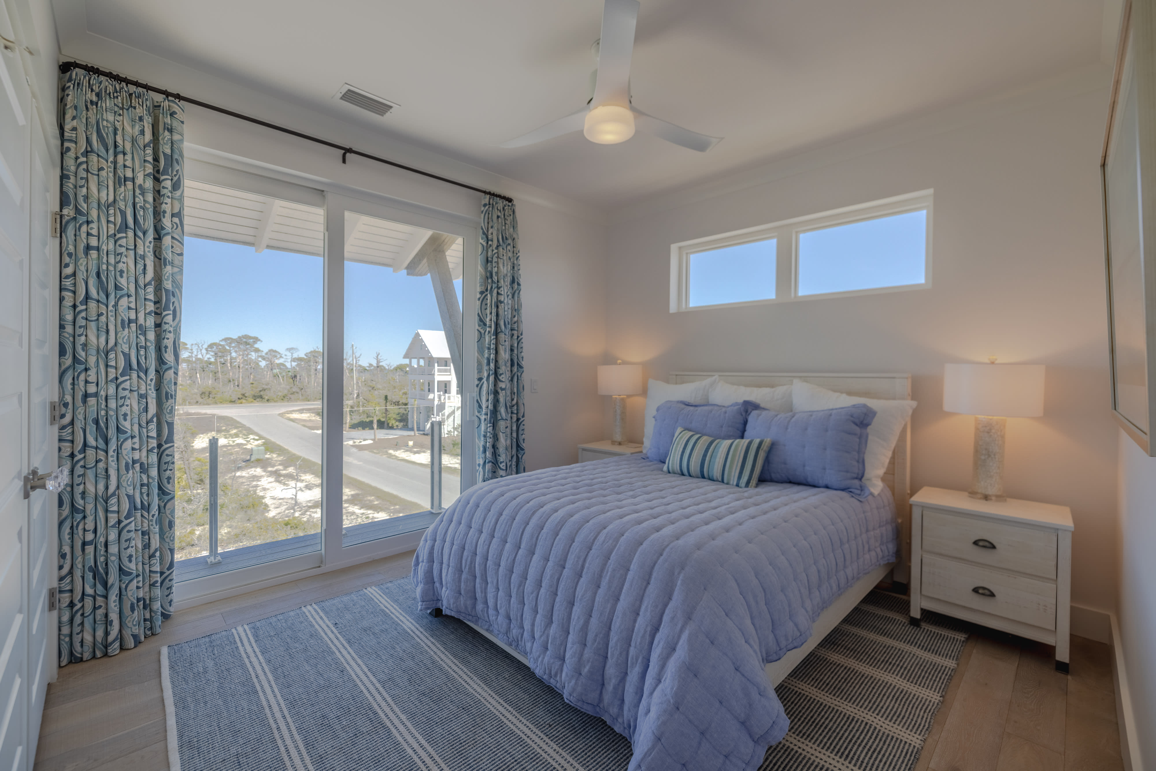 3rd floor bedroom with queen size bed and balcony with views of the bay