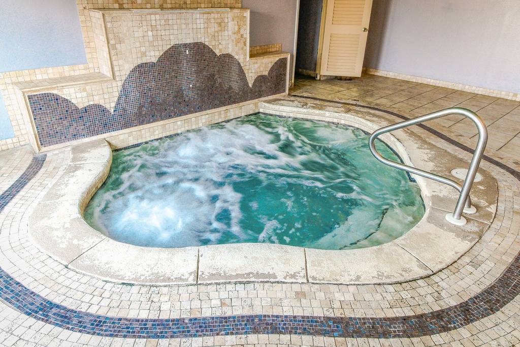 Large Indoor bubbly hot tub, located by the pool area.