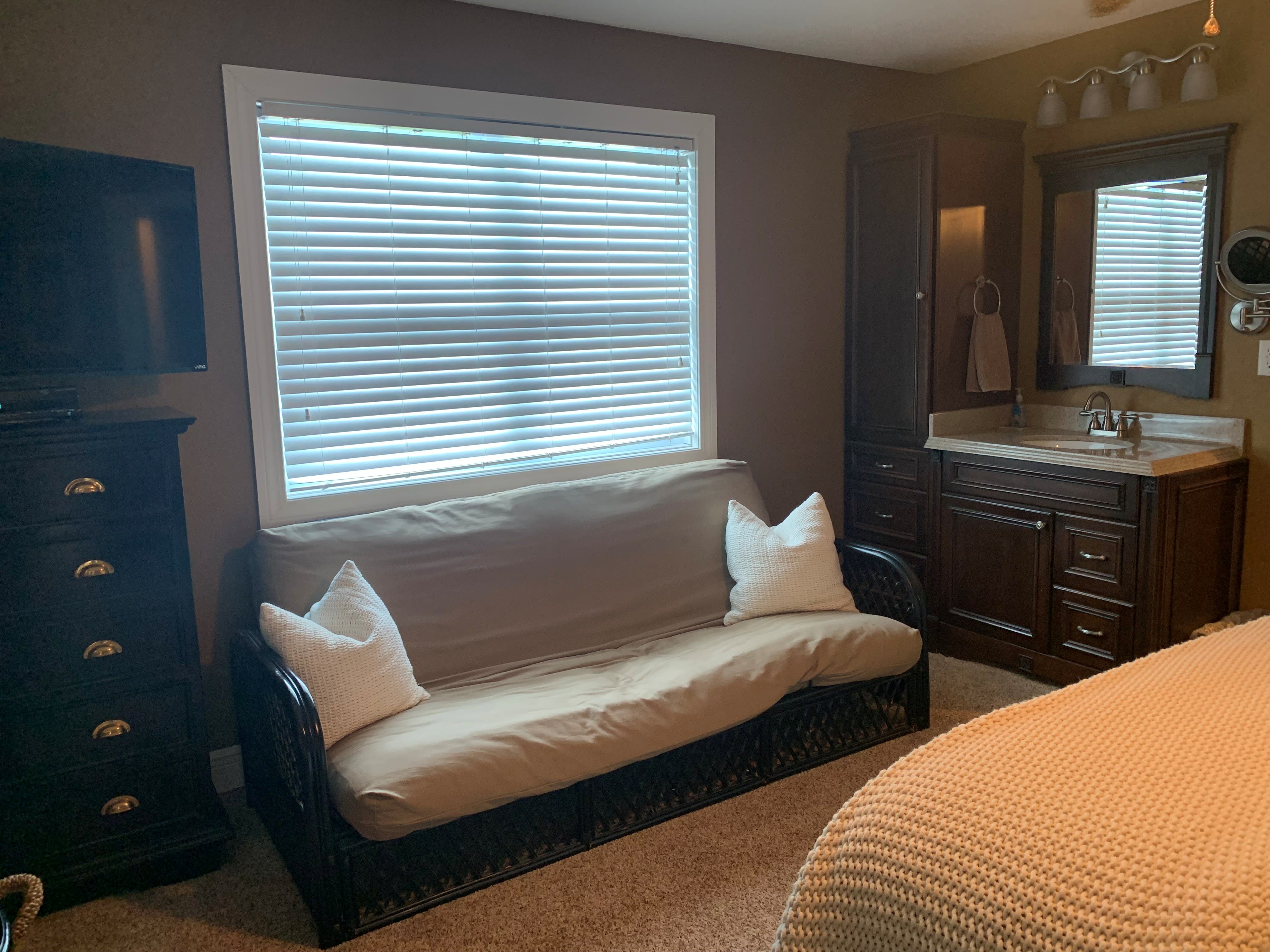 futon and vanity in master bedroom