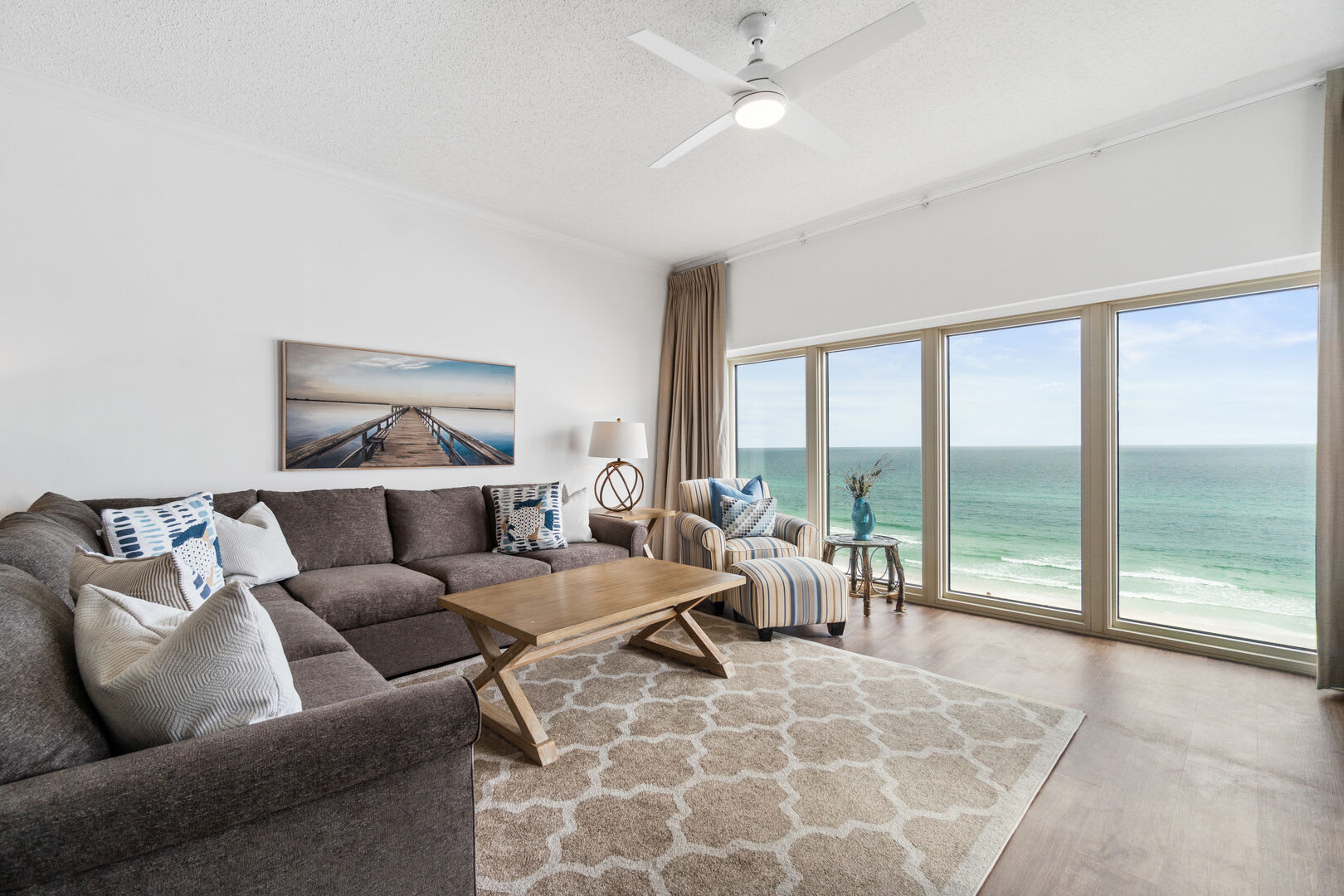 Plenty of room for all to crash, enjoy the view and just relax. L-shaped sofa, club chair with ottoman, and ceiling fan to keep it breezy. Don't forget that magnificent gulf view!