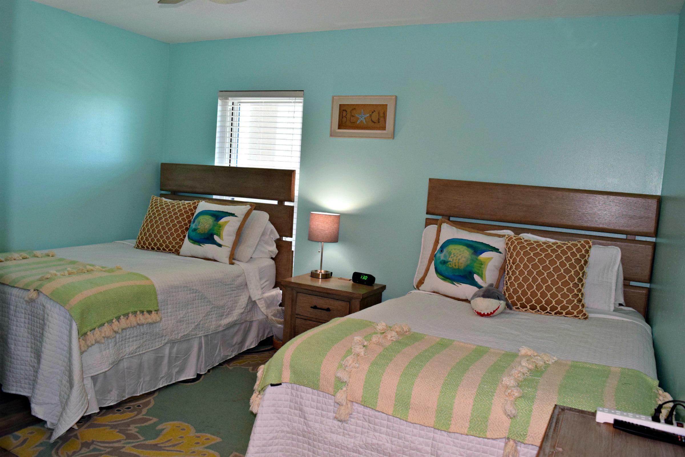Fantastic beach colors and two double beds in this guest bedroom. There is a flat screen mounted to the wall to the right, promise.