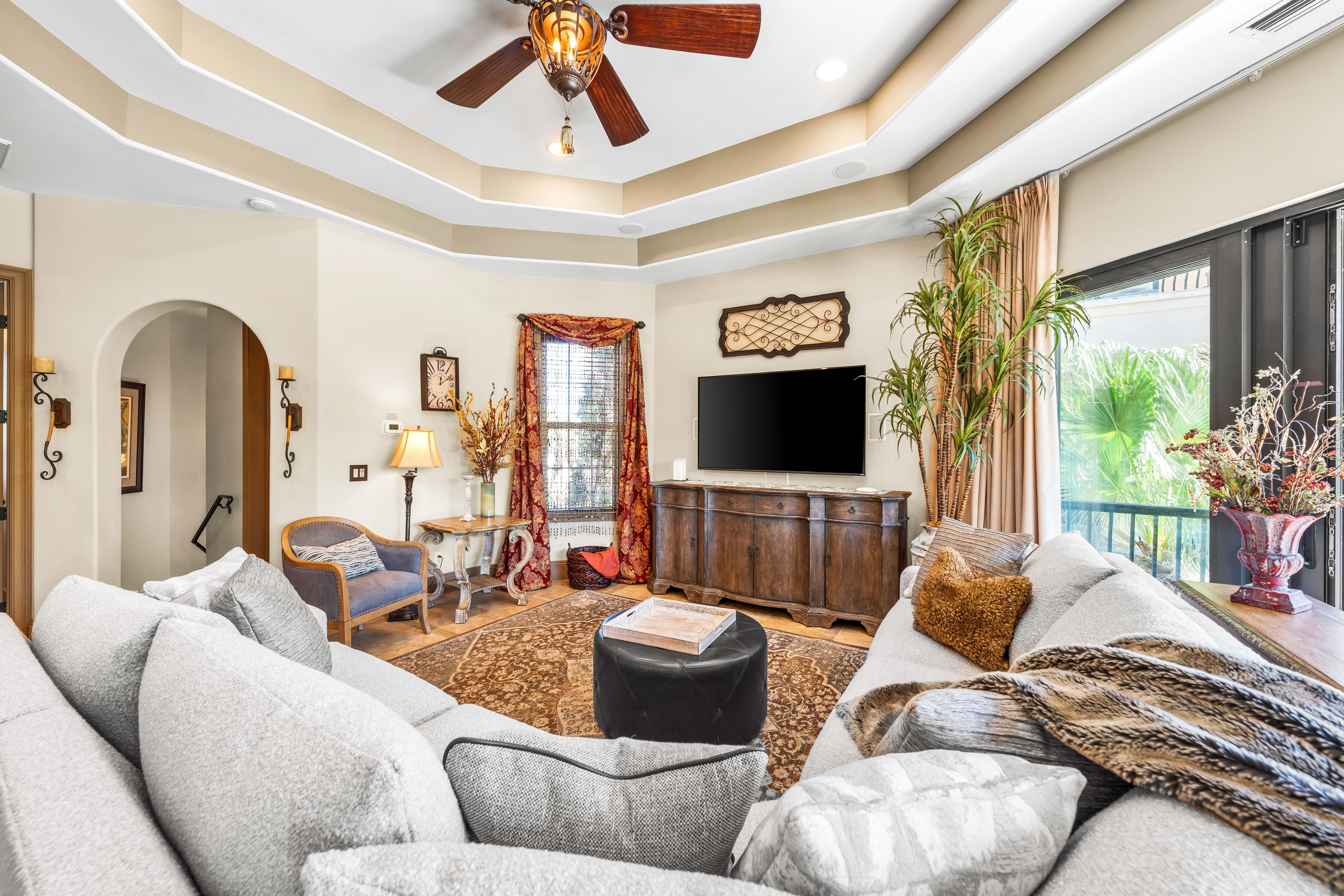 Living area with double tray ceiling & an oversized  70" smart tv