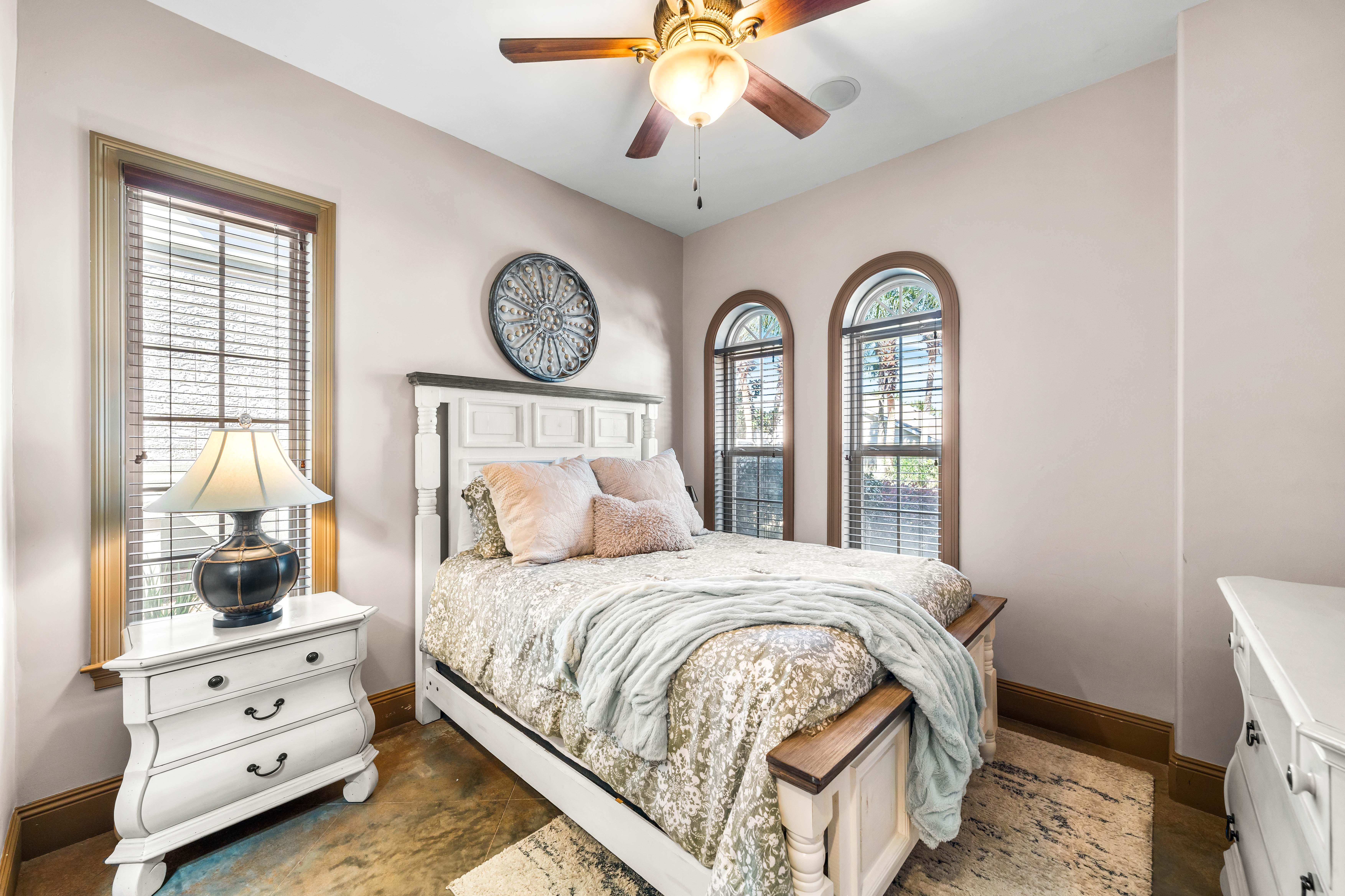 Experience comfort and privacy in this 1st floor bedroom with a queen bed, double arched windows & an en suite bathroom.
