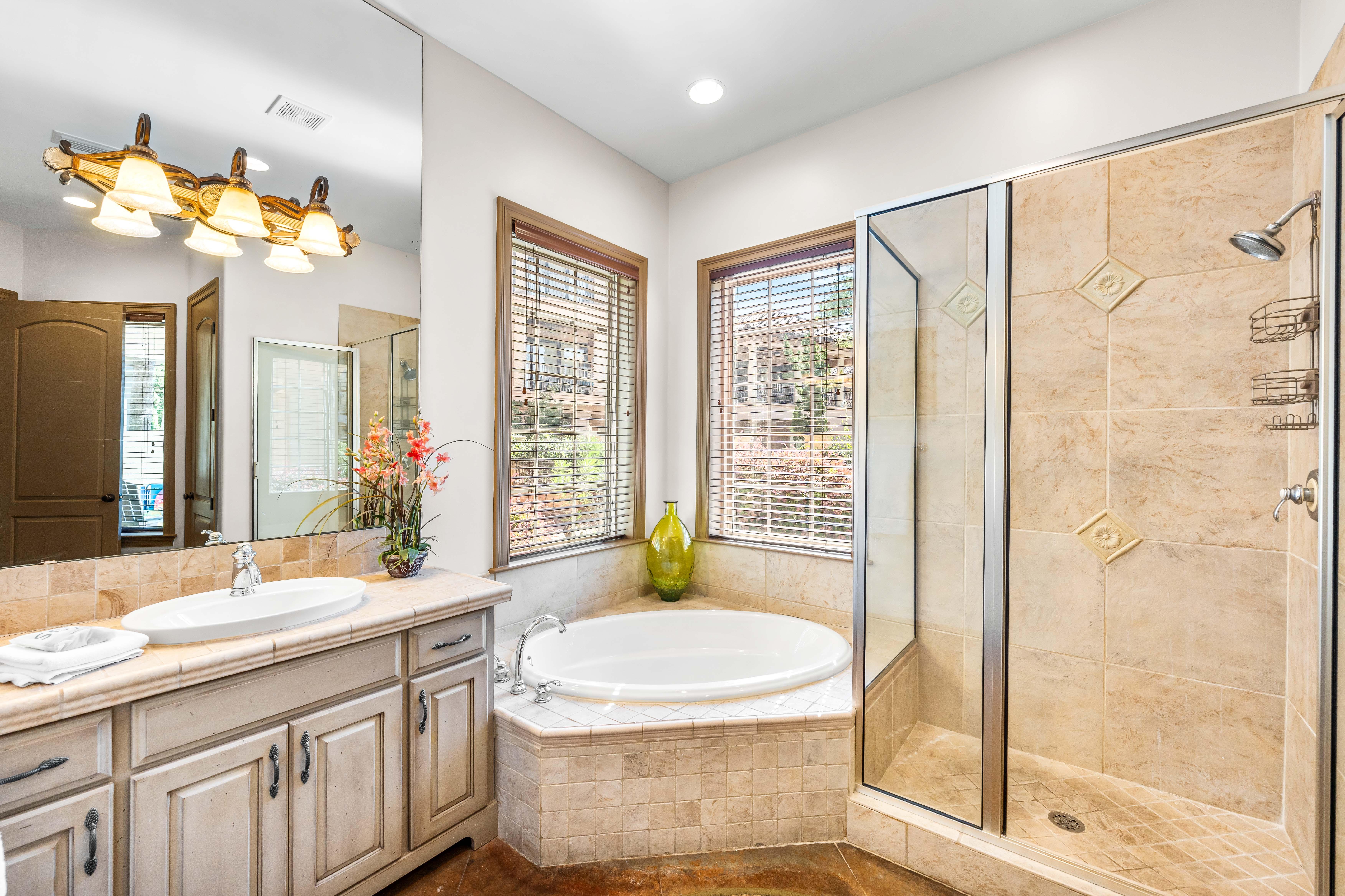 This shared bathroom full bathroom has a separate walk-in shower with the soaking tub and a private water closet.