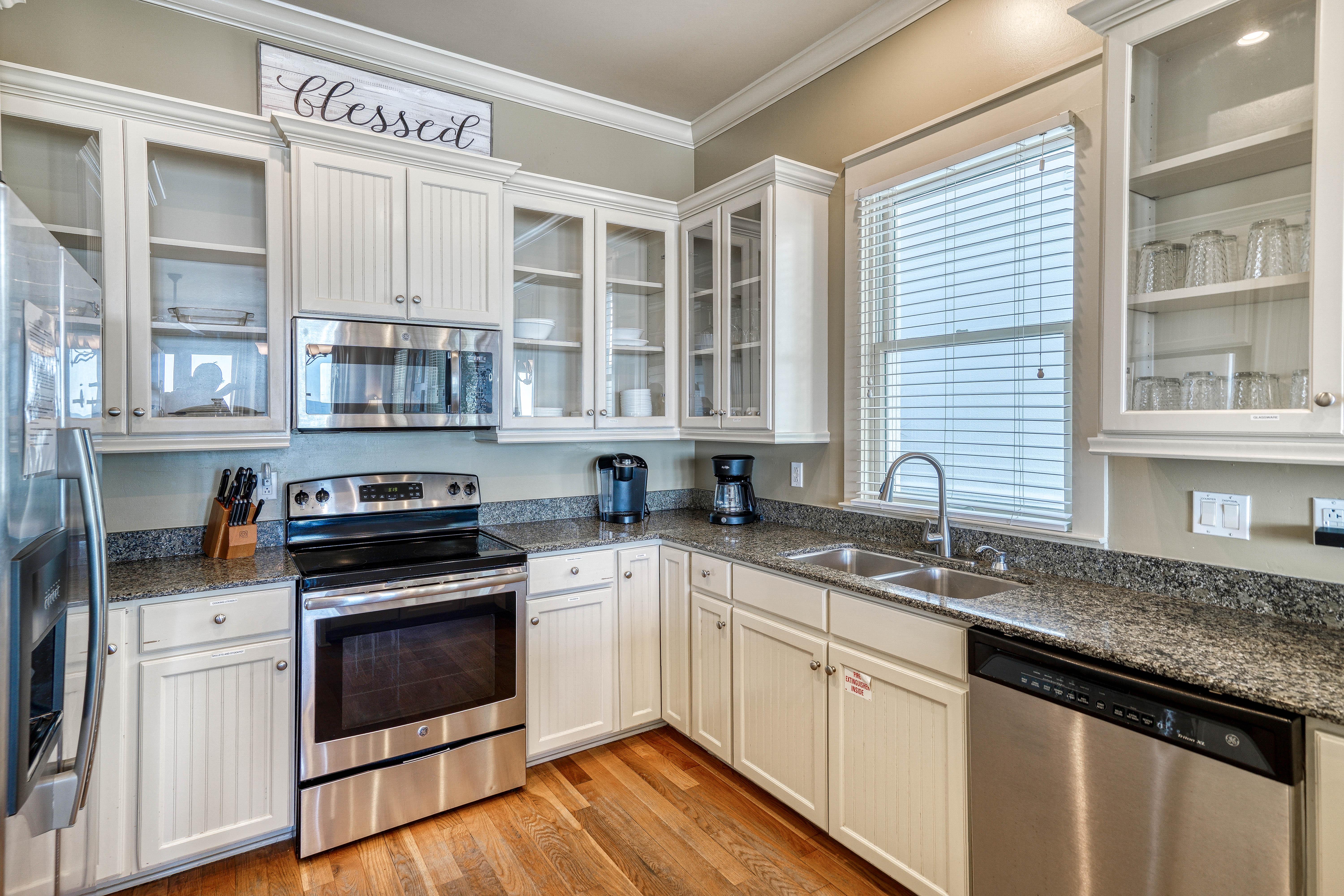 Open Kitchen with Granite Countertops, Stainless Steel Appliances, & Custom Cabinetry Stocked with Cookware & Dinnerware