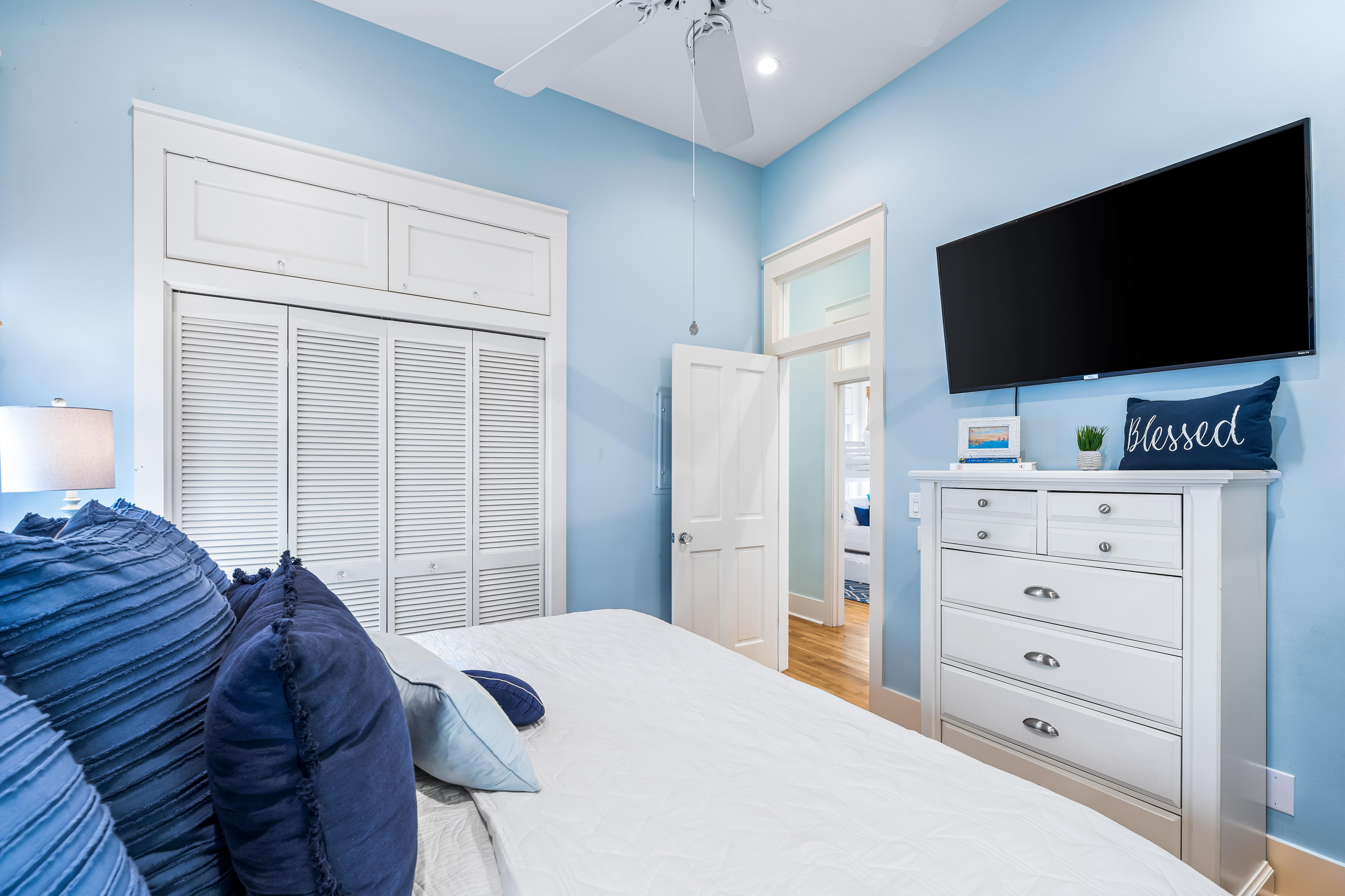 King bedroom with an en suite bathroom, large closet, ceiling  fan, and a 50" Smart TV.  .