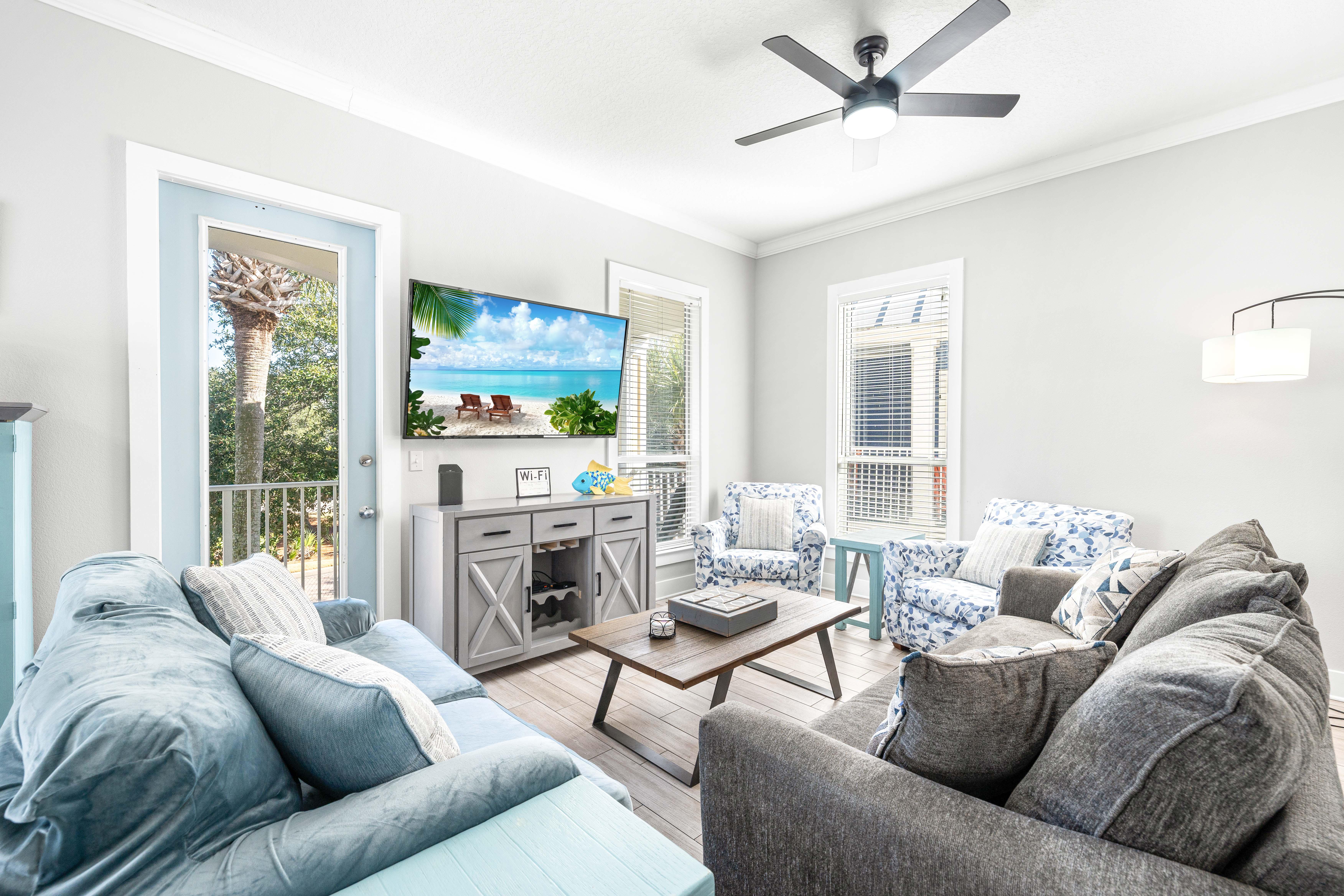 Open floor plan in this 2nd floor main living area with a sleeper sofa and a 65" smart tv.  Large collection of DVDs for the DVD  player!  There's also a balcony with seating for morning coffee or evening cocktails just off the living room overlooking the