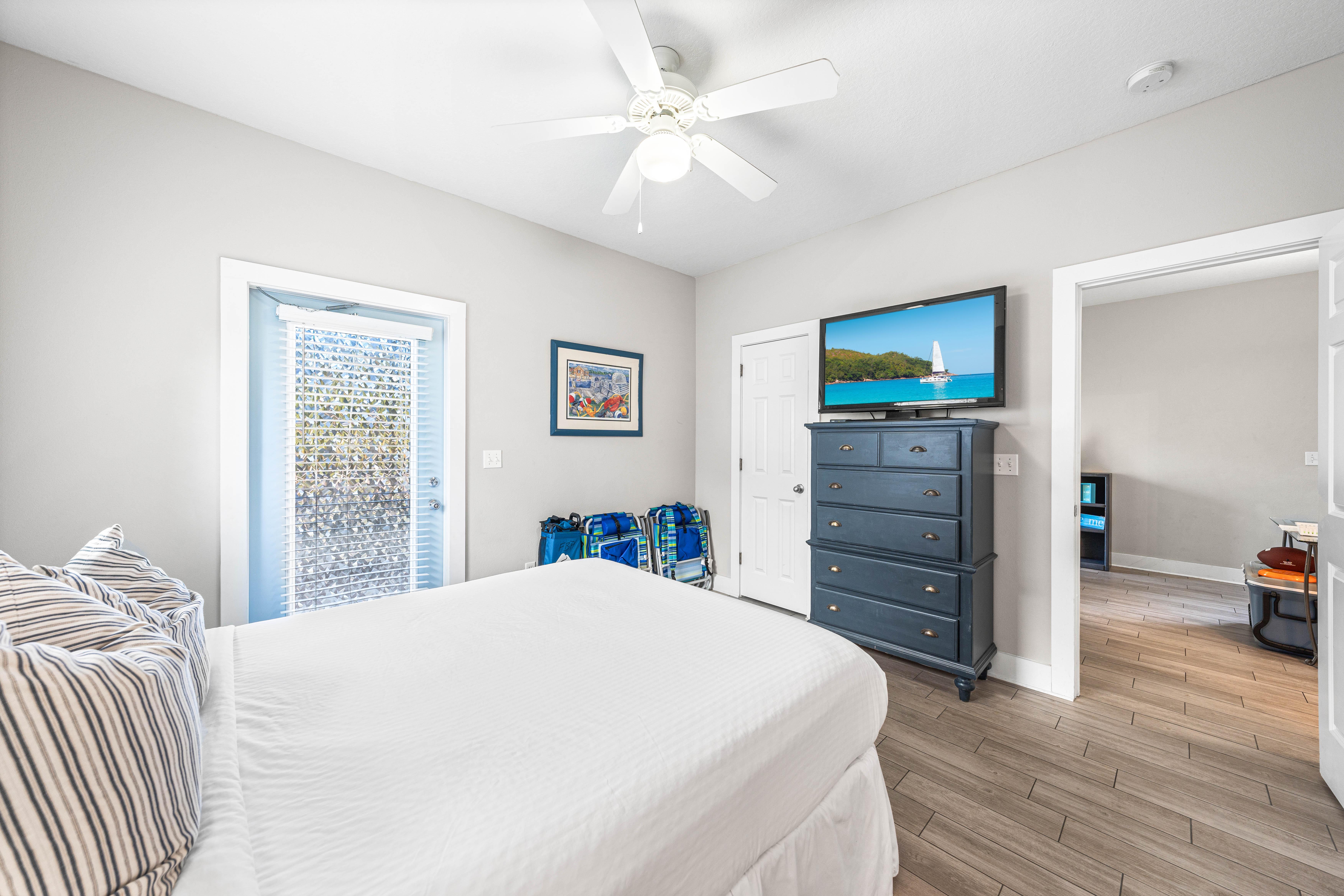 Another view of the first floor bedroom with a queen bed,42" tv, large walk-in closet, additional door out to the front porch, and a full bathroom.