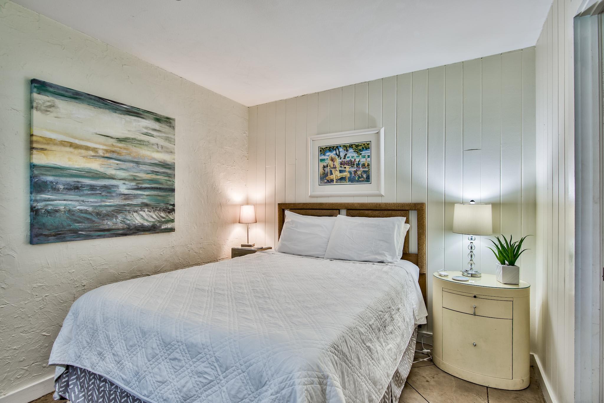 First bedroom on the west end of Seabreeze with Queen bed, walk-in closet, & adjacent full bathroom with walk-in shower.