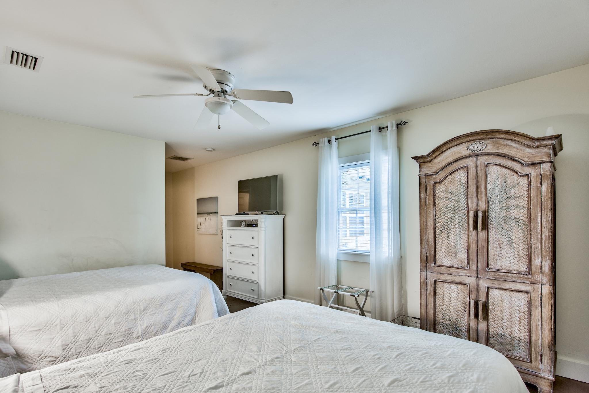 East end of Seabreeze has a 2nd bedroom with 2 queen beds & adjacent full bathroom with a walk-in shower.   TV located above the chest of drawers.