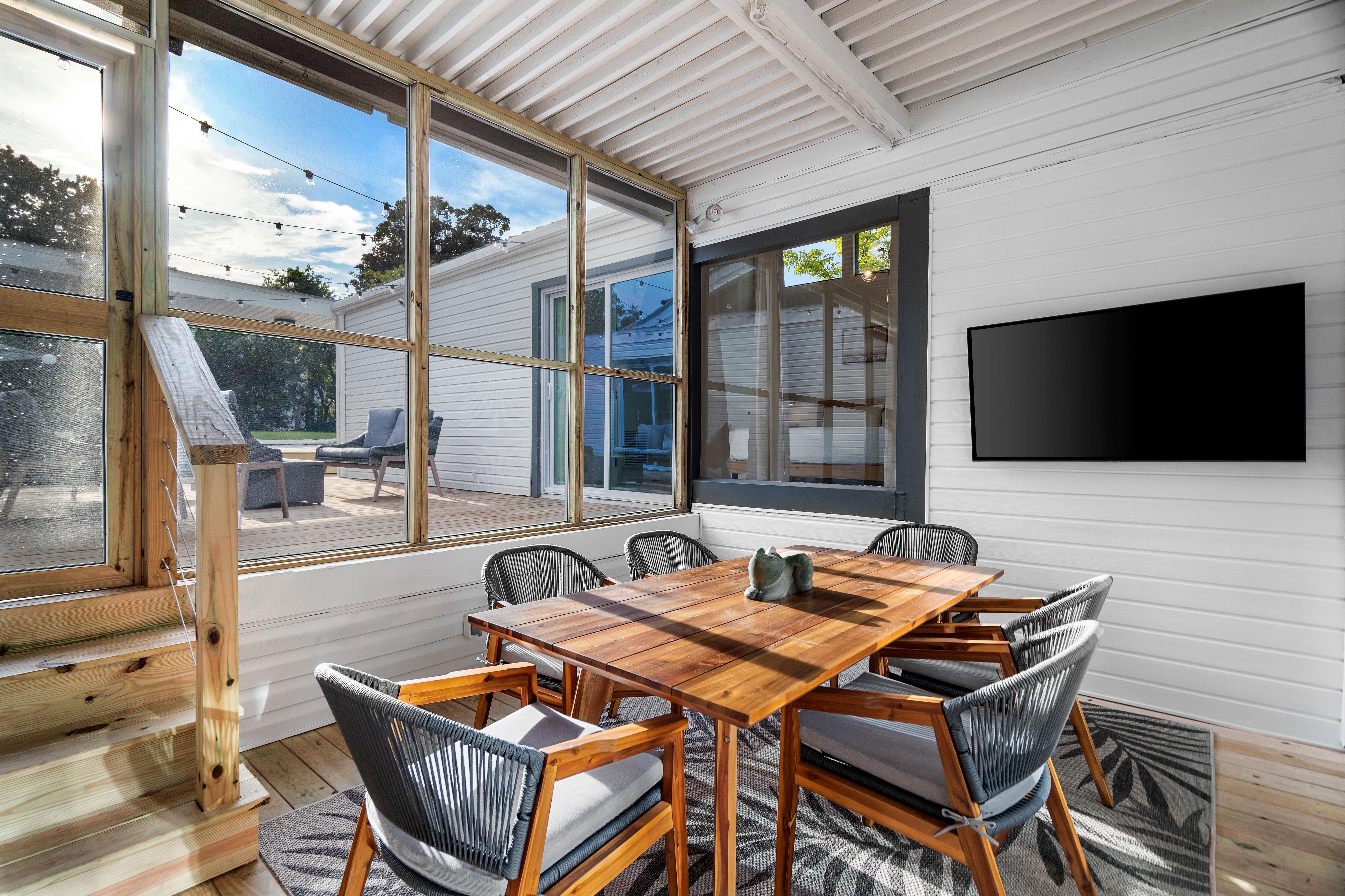 Just off the Kitchen is Another Dining Area Seating on A Covered Screened in Patio with a 58" Smart TV.
