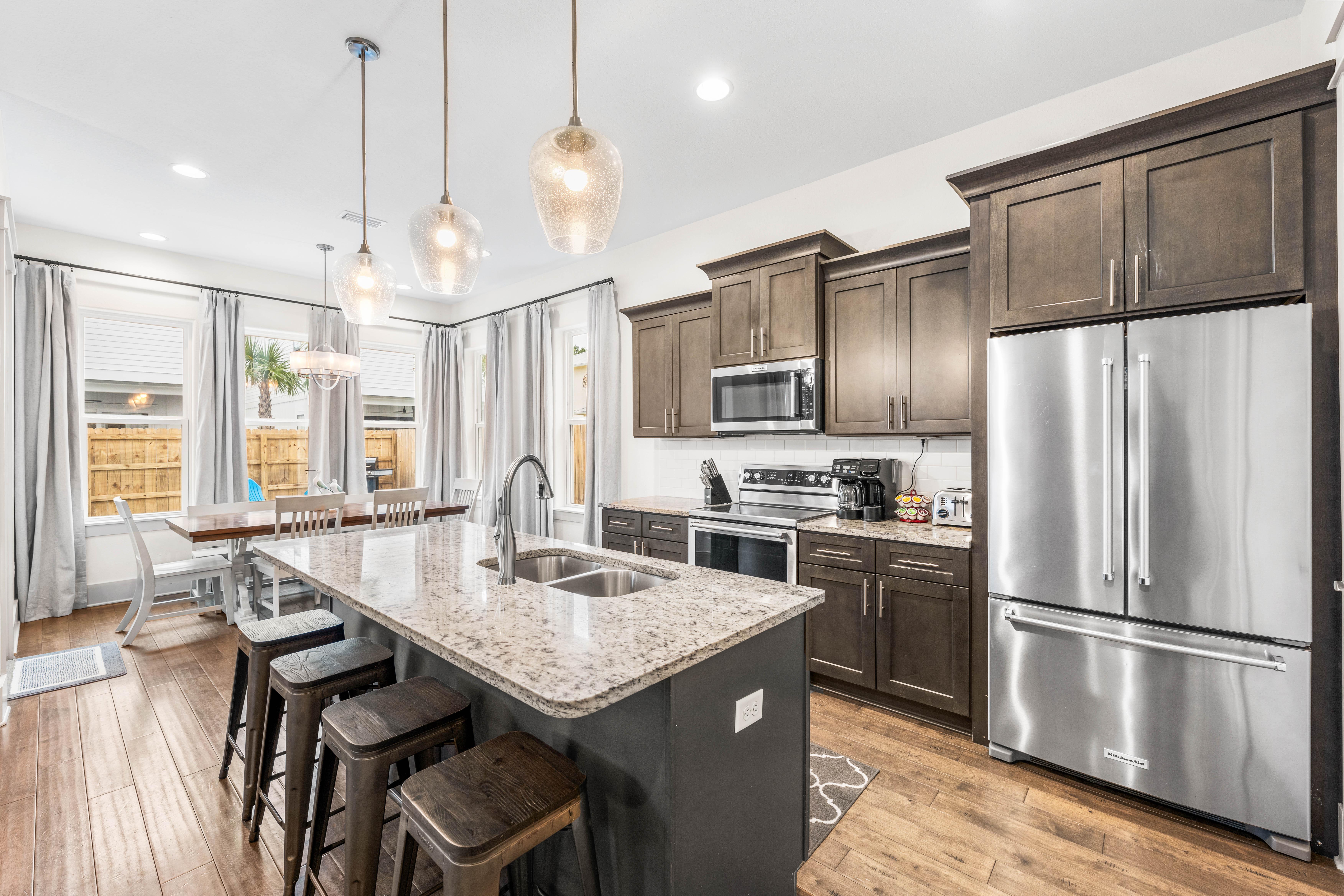 Cook like a chef in this fully stocked kitchen with KitchenAid stainless steel appliances, granite countertops, & island seating for 4