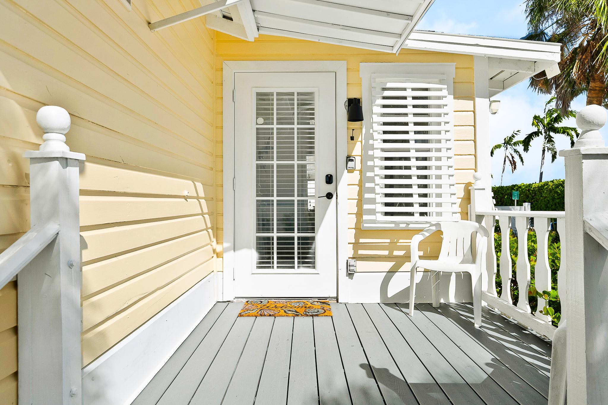 Nestled among palms, this cozy single-story bungalow features a shaded front porch and coastal-style shutters just steps from sandy shores.