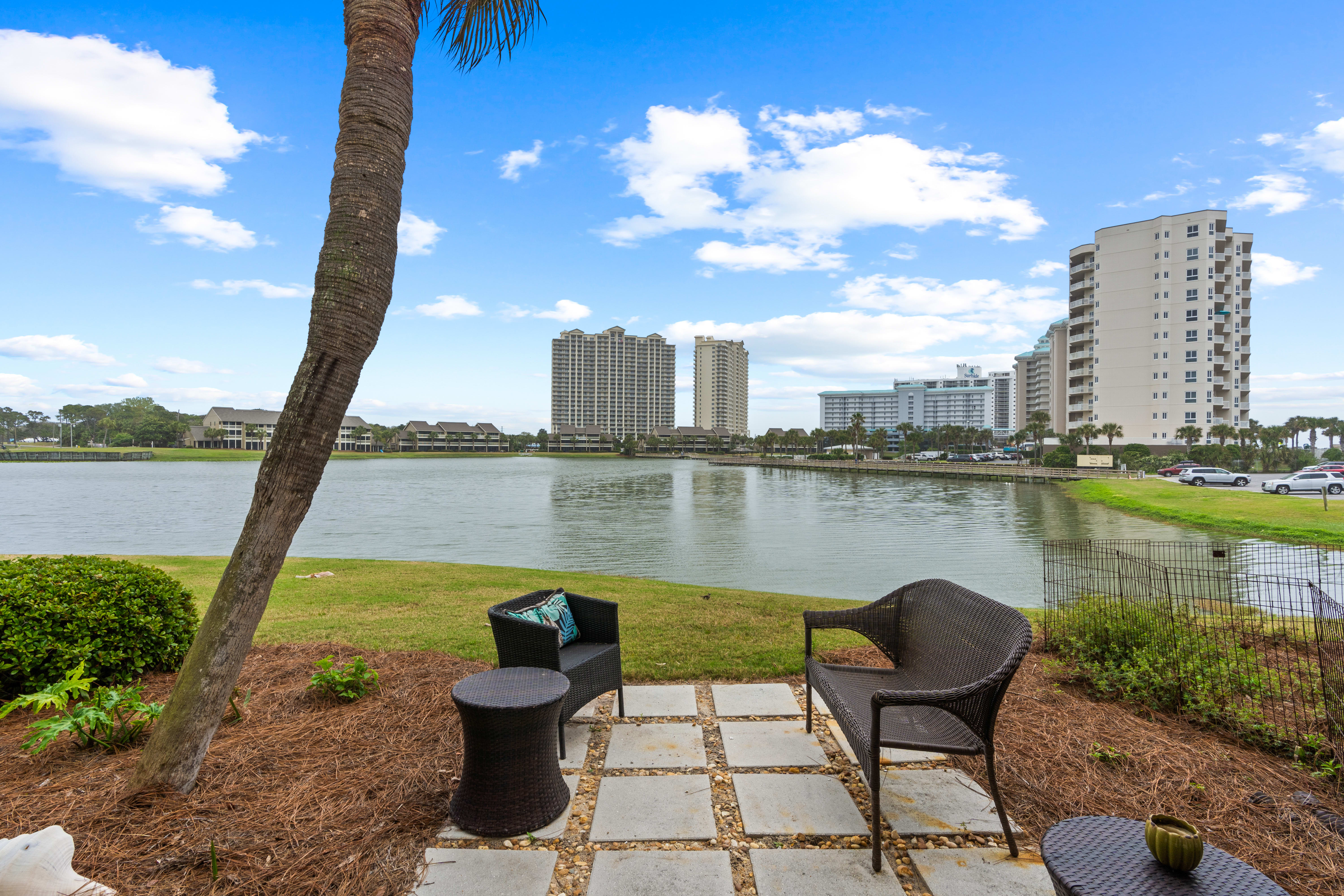 Unwind in your private lakeside oasis with stunning water views and comfortable seating under swaying palms.