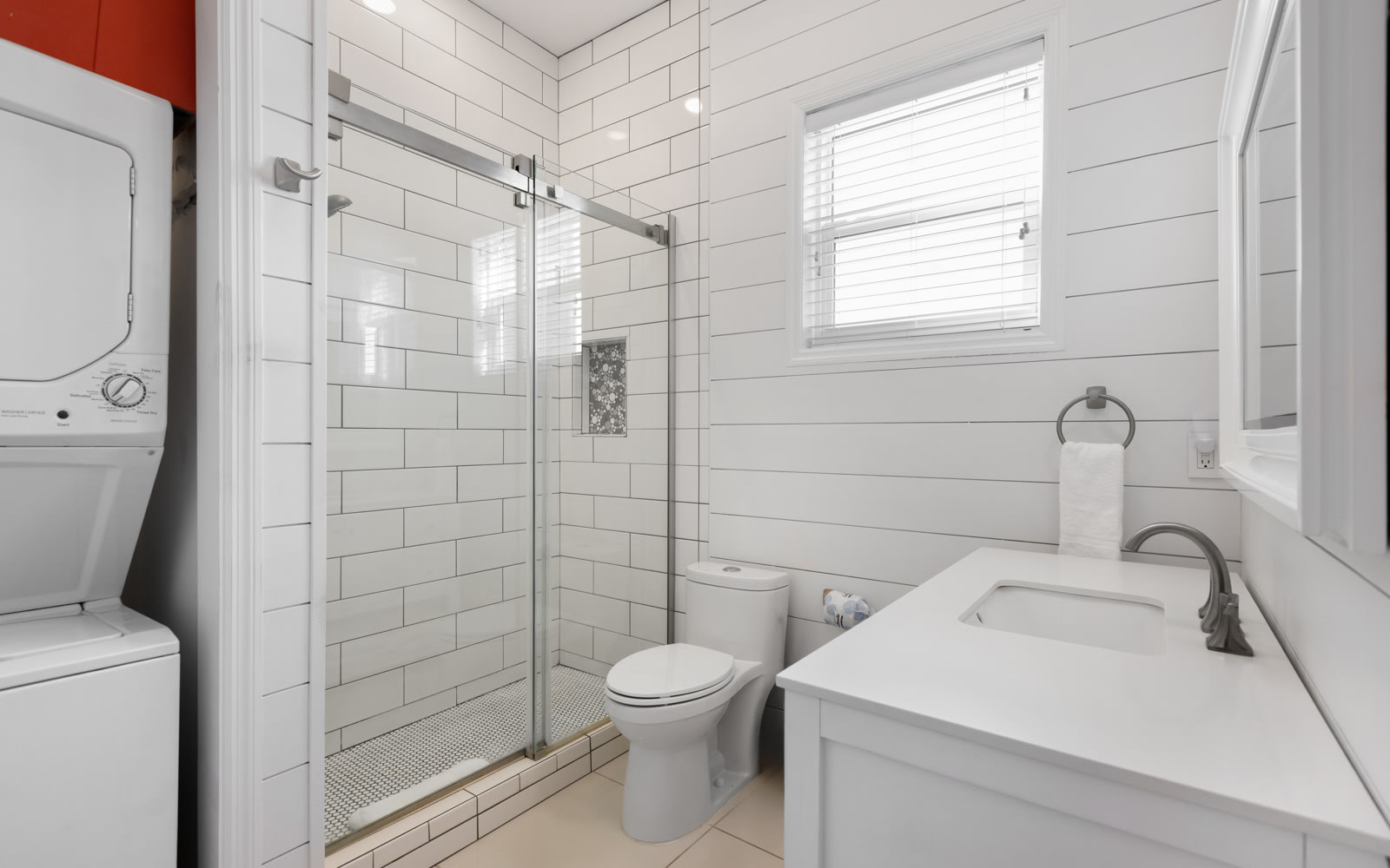 Unwind in your bright, modern bathroom featuring a spacious glass shower, crisp white subway tiles, and fresh towels waiting for you.