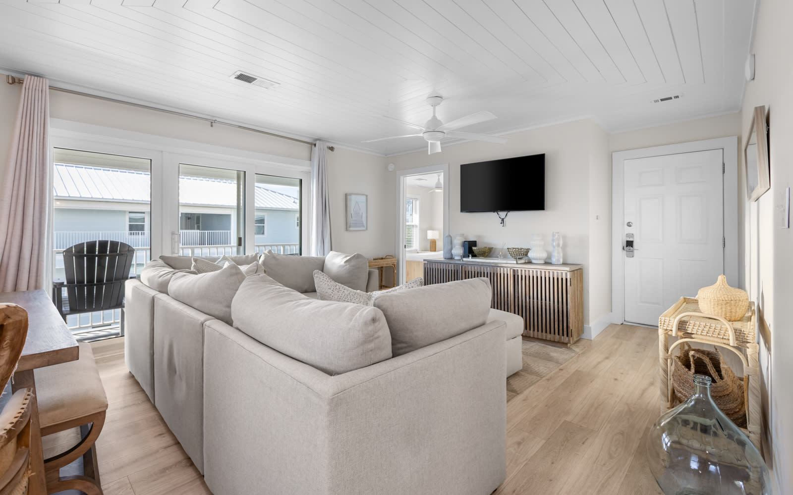 Relax in your bright living space with plush seating, modern entertainment, and large windows showcasing peaceful neighborhood views.