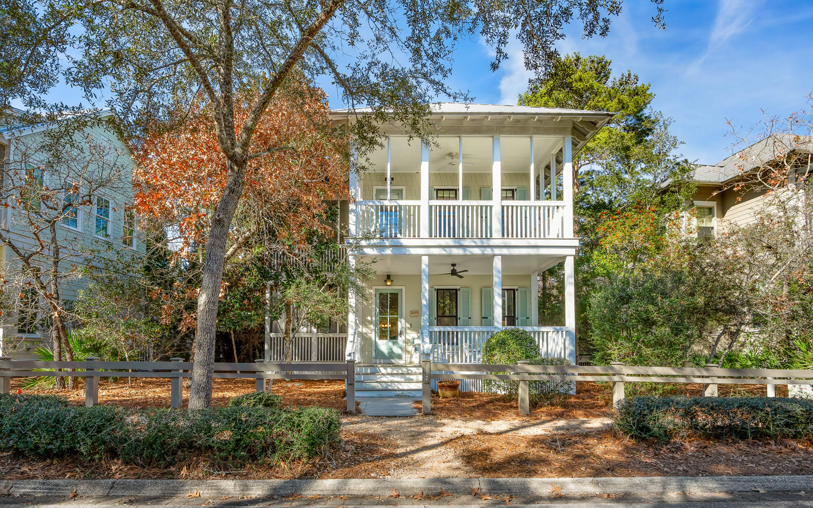 Charming Southern-style home featuring double-story wraparound porches and peaceful tree-lined street location.