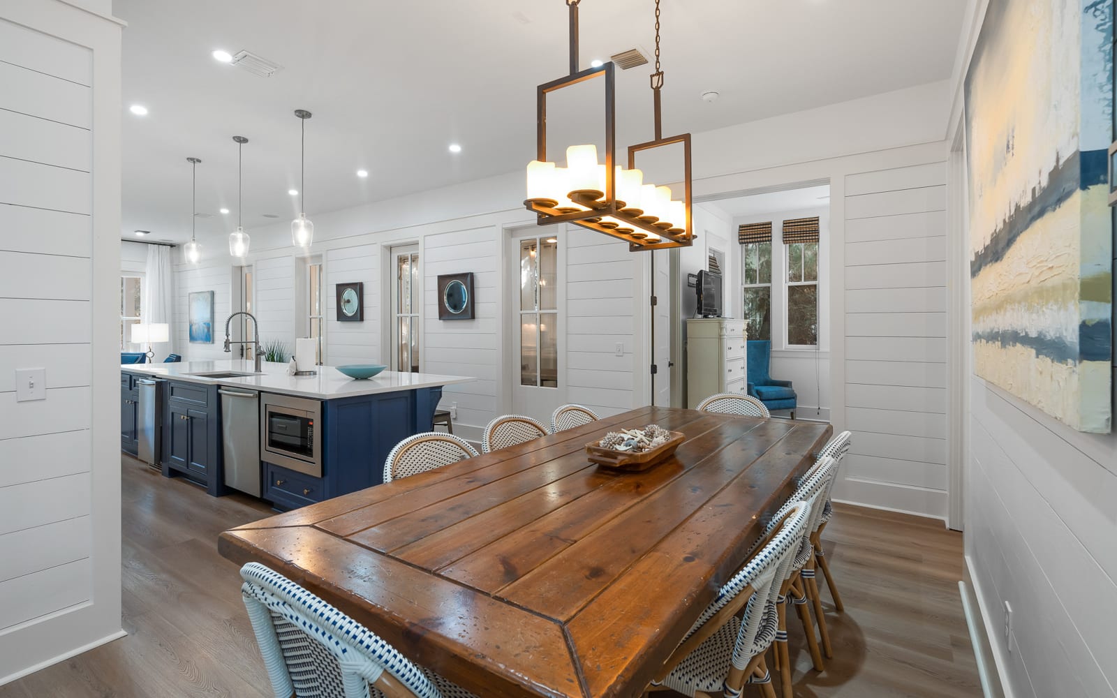 Gather around this stunning farmhouse dining space where warm wood meets coastal charm, perfect for memorable meals.