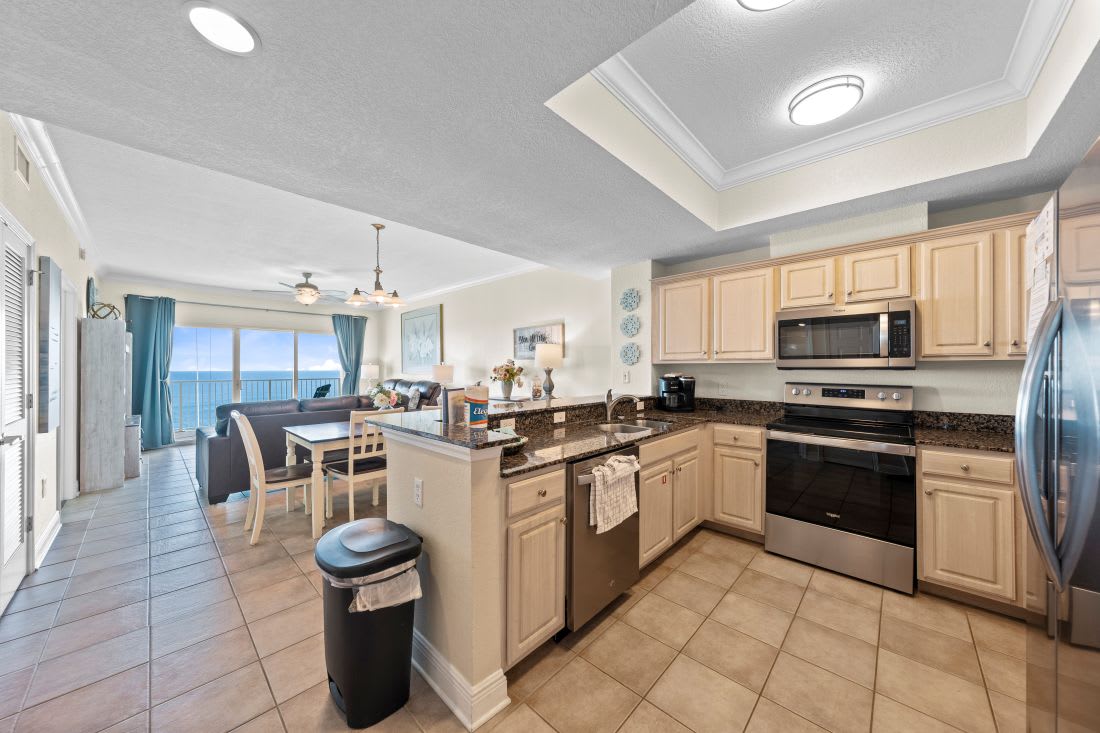 Your fully equipped kitchen opens to stunning ocean views, perfect for preparing meals while enjoying the endless blue horizon through floor-to-ceiling windows.