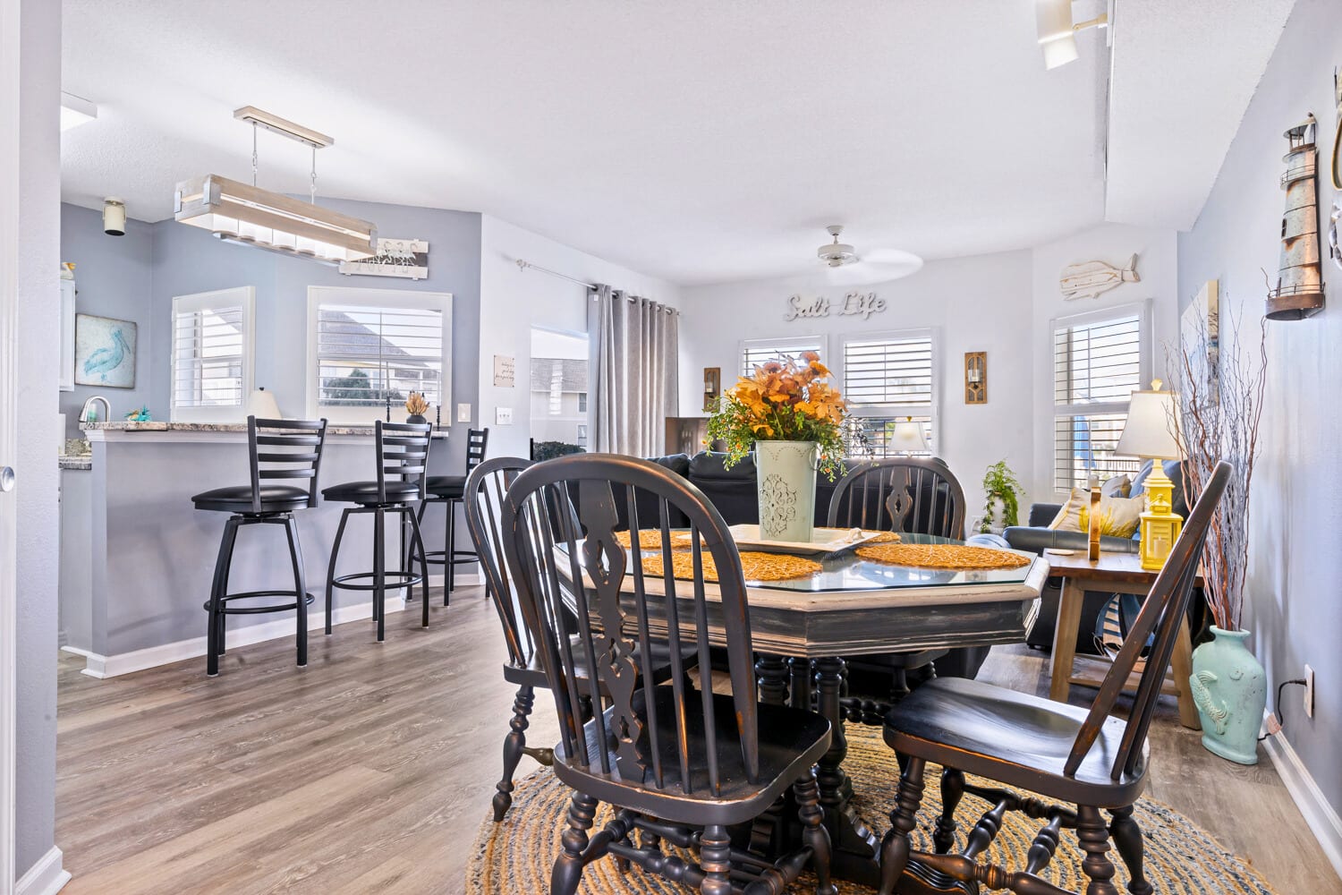 Gather around your elegant dining table for memorable meals, with the open kitchen perfect for cooking together and coastal decor creating a relaxing atmosphere.