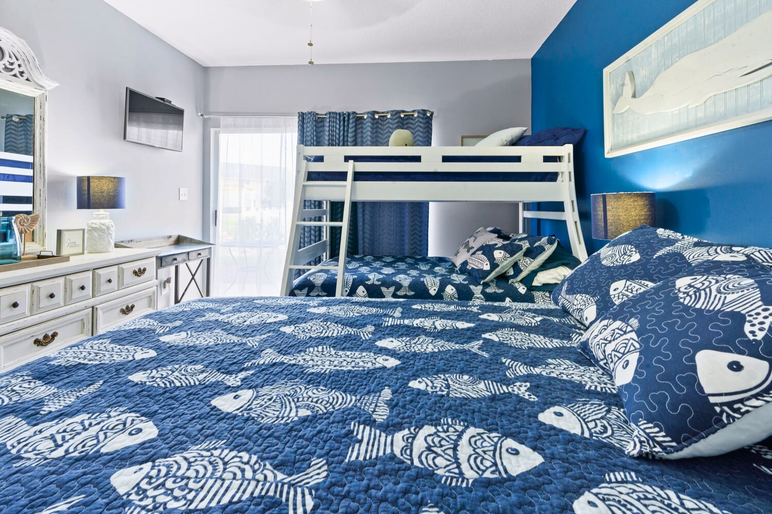 Your family bedroom features a king bed and bunk bed with nautical-themed bedding, creating the perfect space for everyone to rest comfortably.