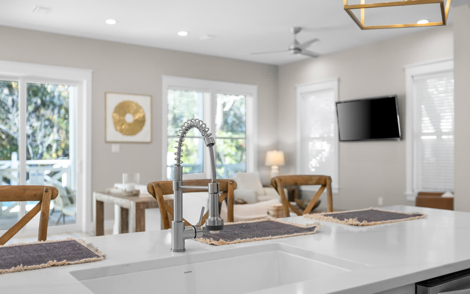 Your modern kitchen island flows seamlessly into a bright living space, where warm wood accents and natural light create the perfect gathering spot for your getaway.