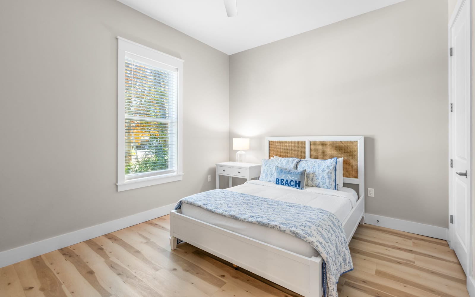 Wake up refreshed in your serene bedroom with natural light streaming through the window and soft coastal touches.