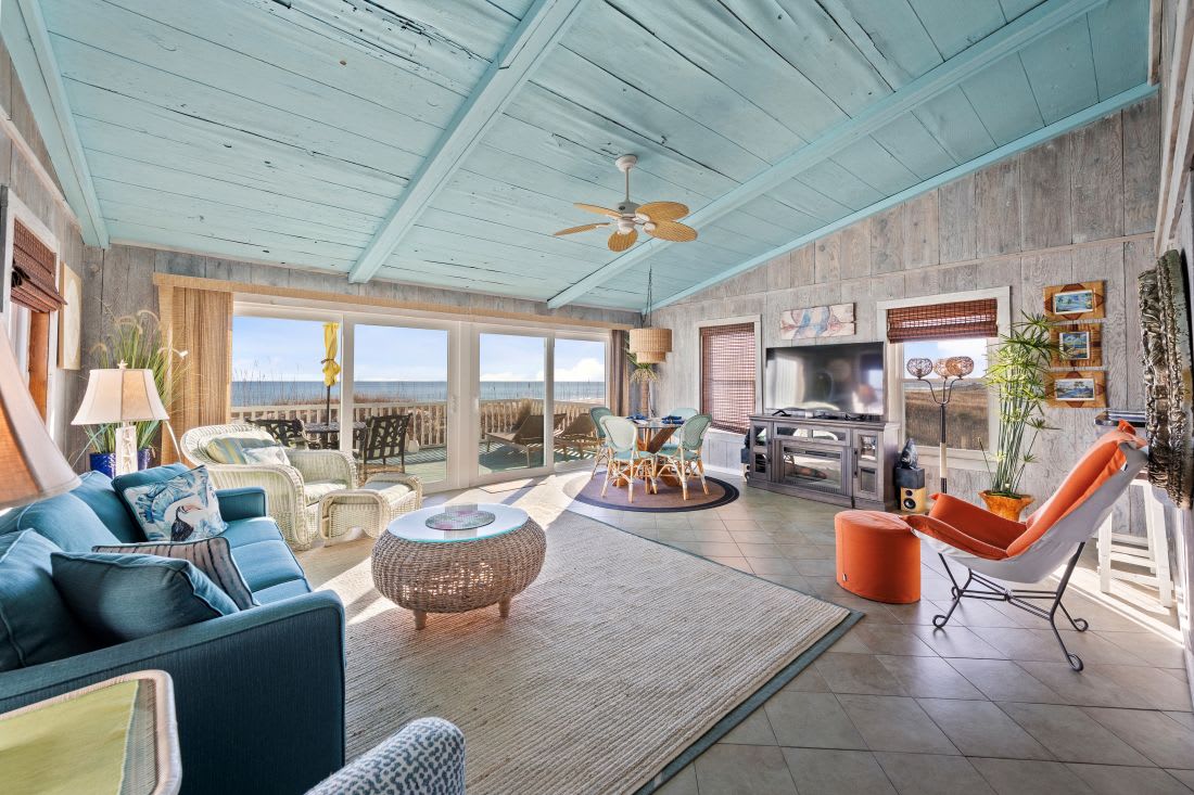 Unwind in your coastal living room where ocean views stretch endlessly beyond the windows, creating the perfect backdrop for relaxation.