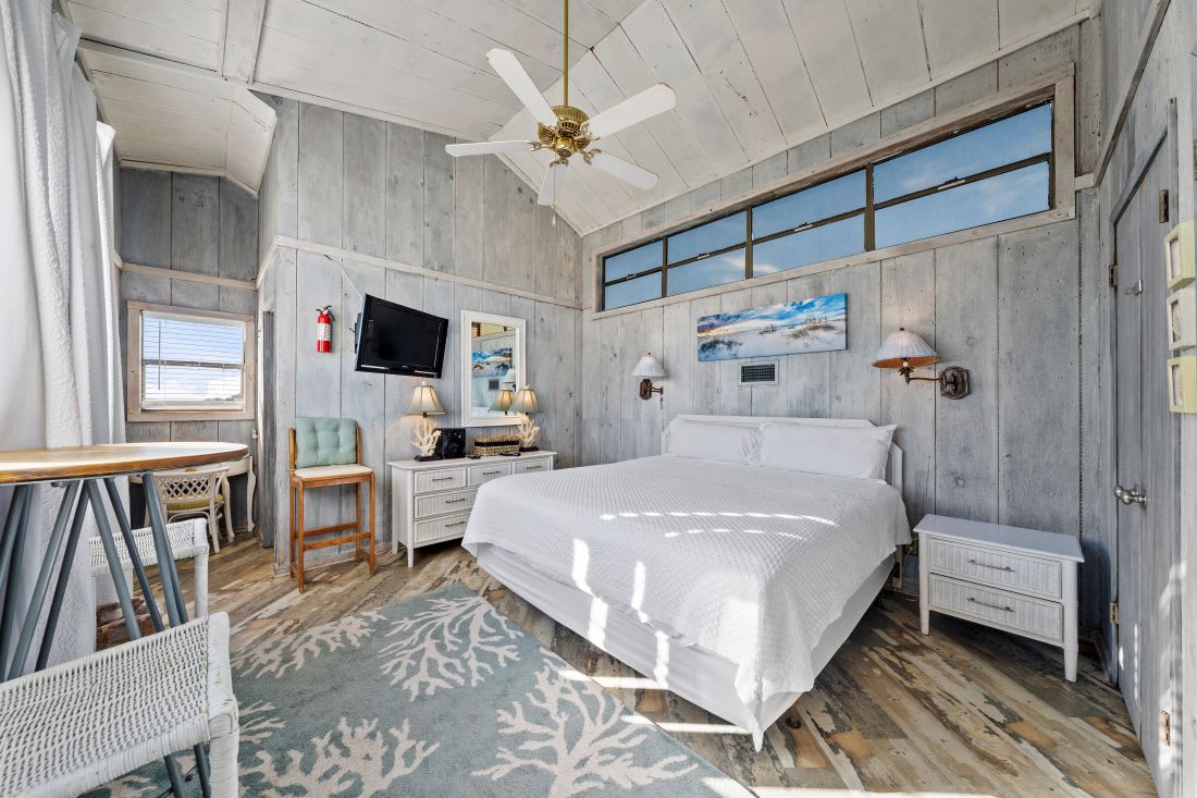 Drift off in this coastal bedroom where weathered wood meets ocean-inspired decor, your morning light streaming through oversized windows.