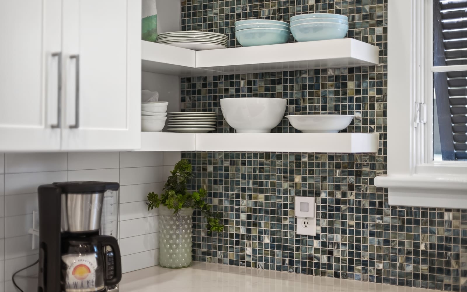 Your fully equipped kitchen features elegant open shelving with quality dishes and a stylish mosaic backsplash for your culinary adventures.