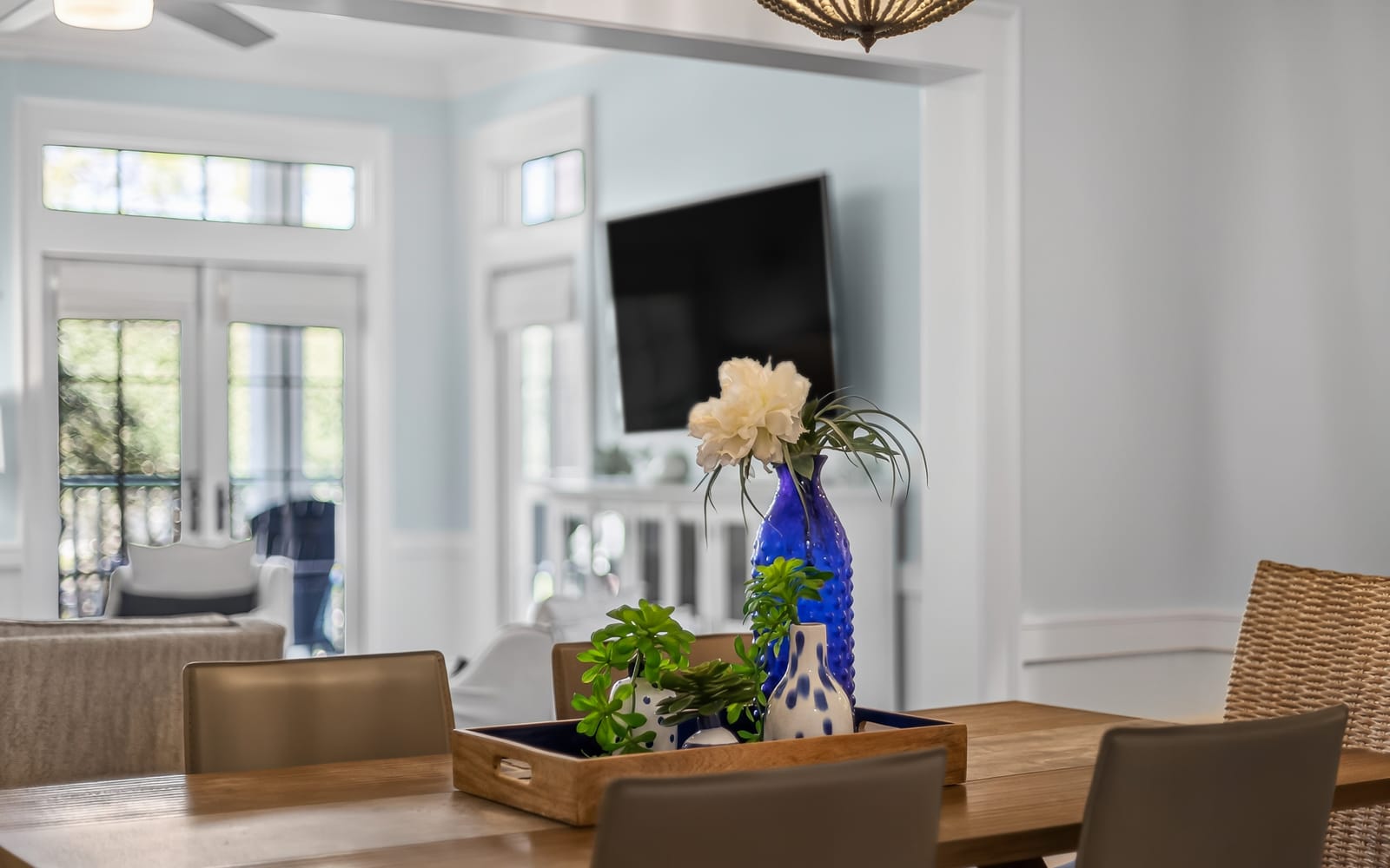 Your elegant dining space features a beautiful wooden table and stylish centerpiece, with the bright living area just steps away for easy entertaining.