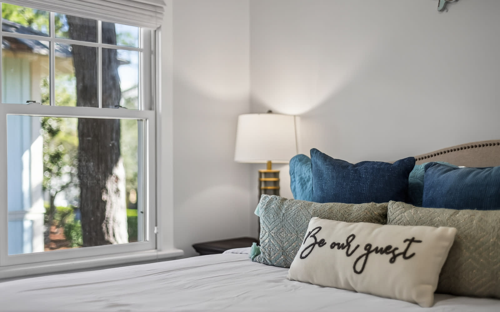 Sink into plush pillows and cozy textures in your beautifully appointed bedroom, where morning light streams through charming windows.