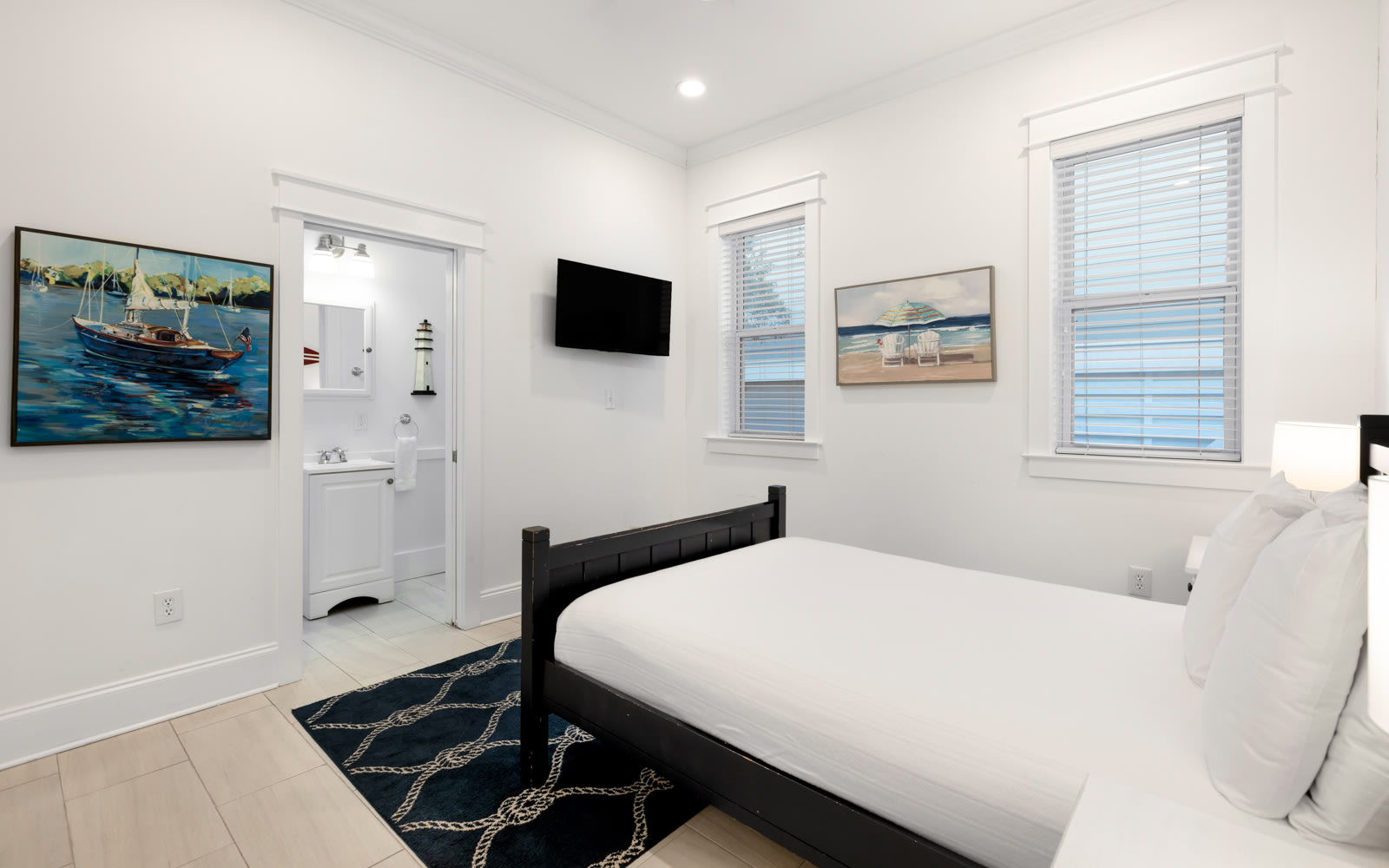 Drift off to sleep in your coastal-themed bedroom, where nautical artwork and crisp white linens create a serene retreat with modern conveniences.