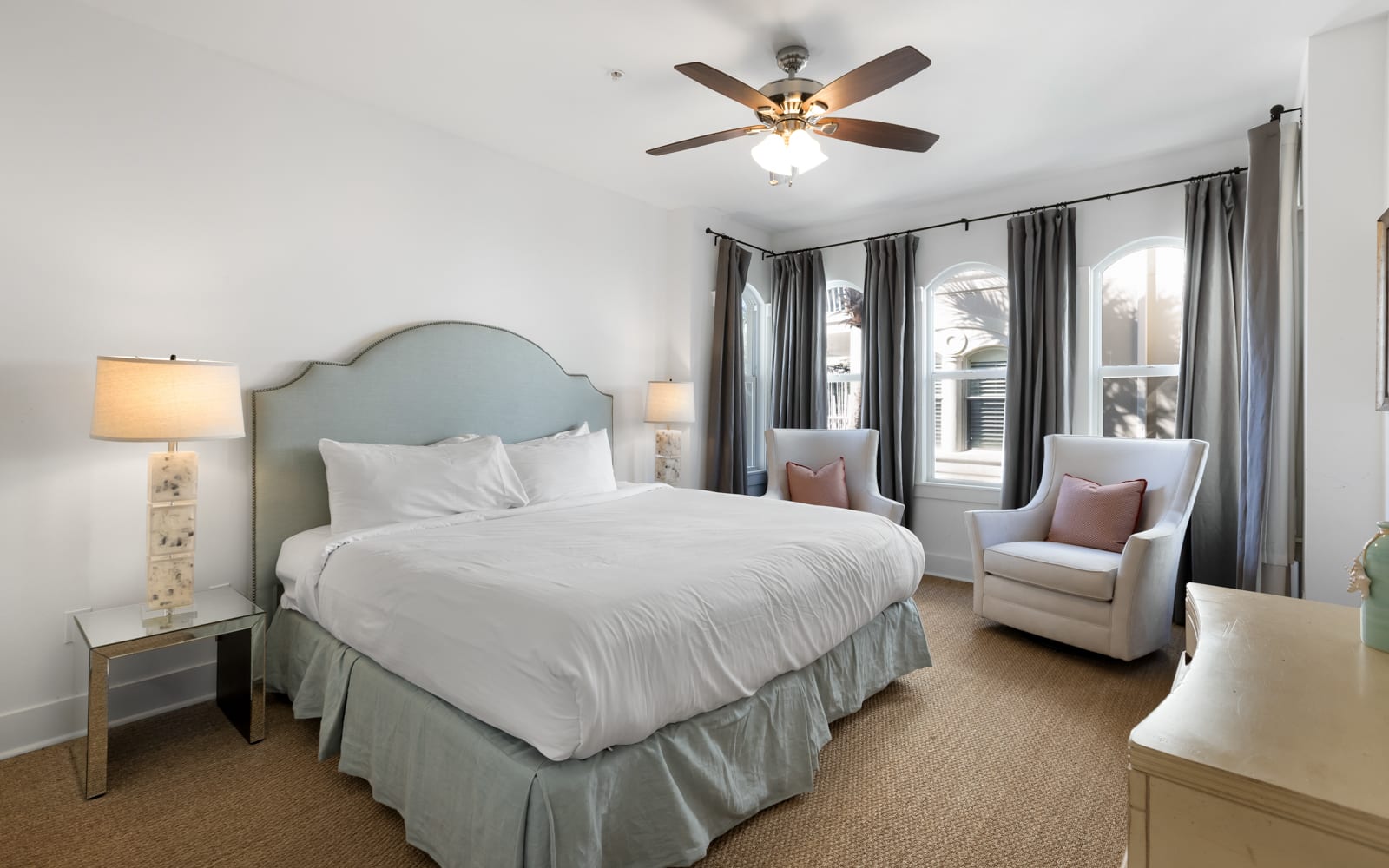 Sink into crisp white linens and unwind in your elegant reading chairs, where soft lighting creates the perfect sanctuary for rest.