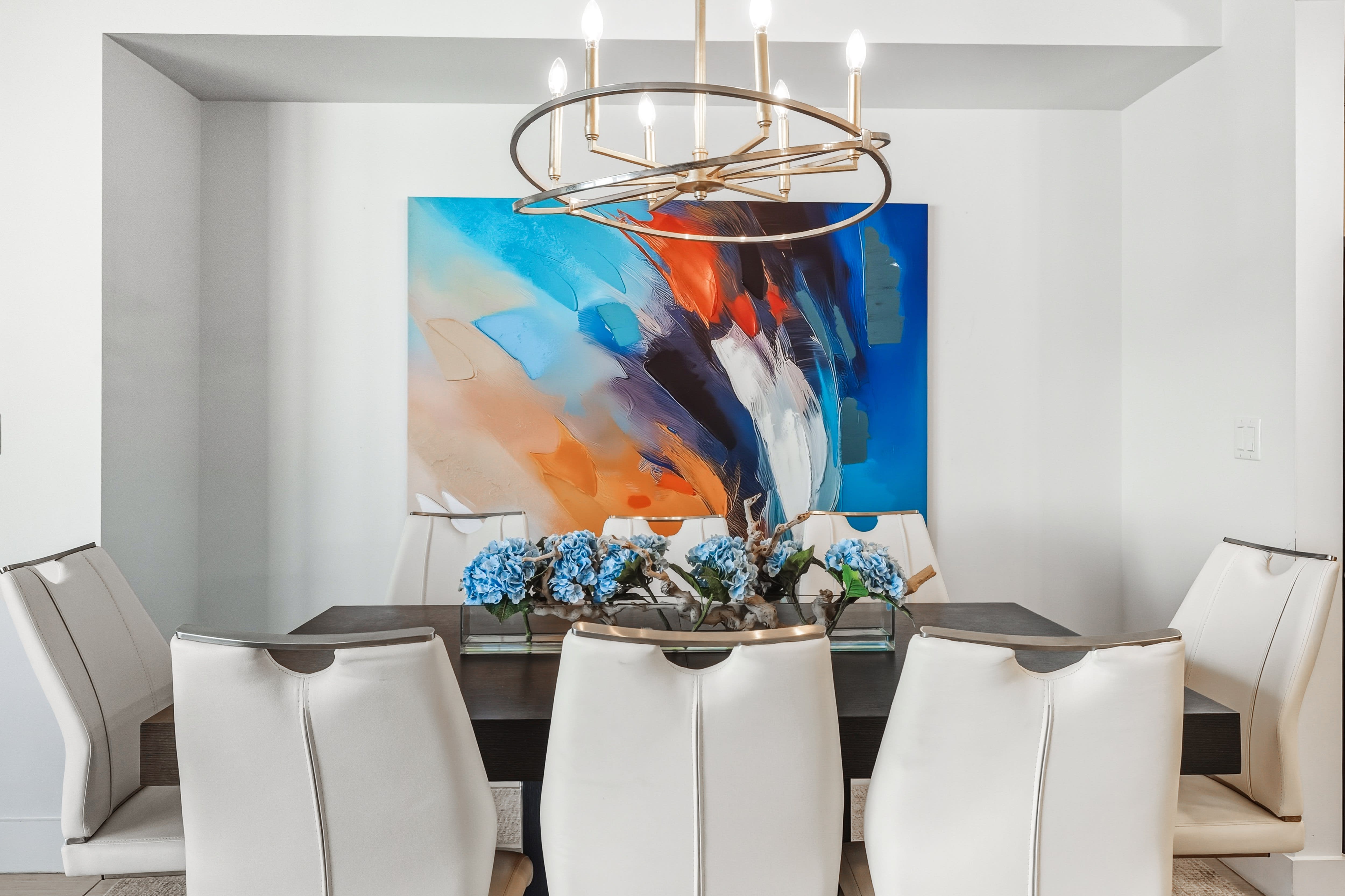 Your elegant dining space features a striking chandelier and bold artwork, perfect for memorable meals with loved ones.