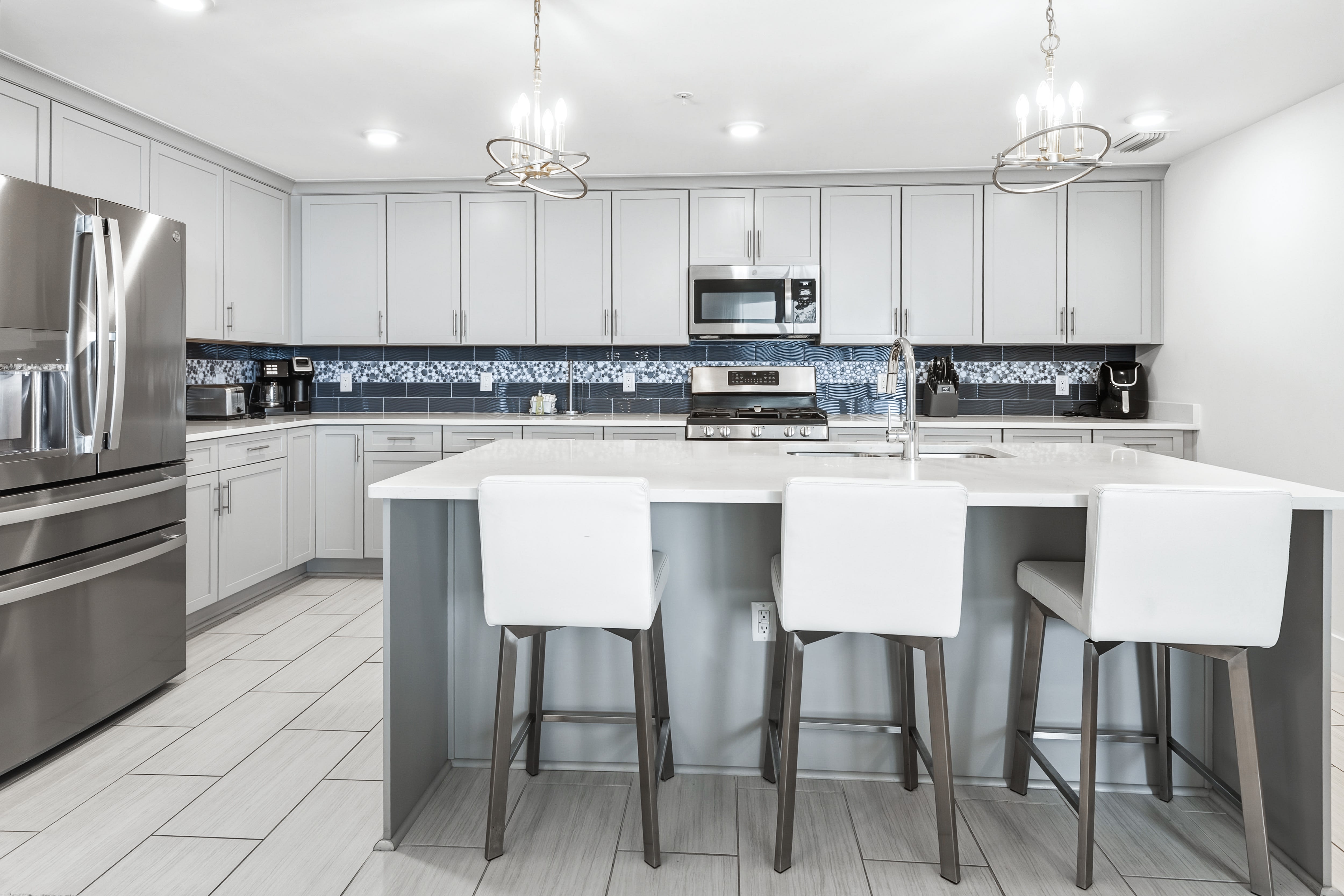Your gourmet kitchen awaits with gleaming quartz countertops, modern appliances, and stylish island seating for memorable meal prep and casual dining.