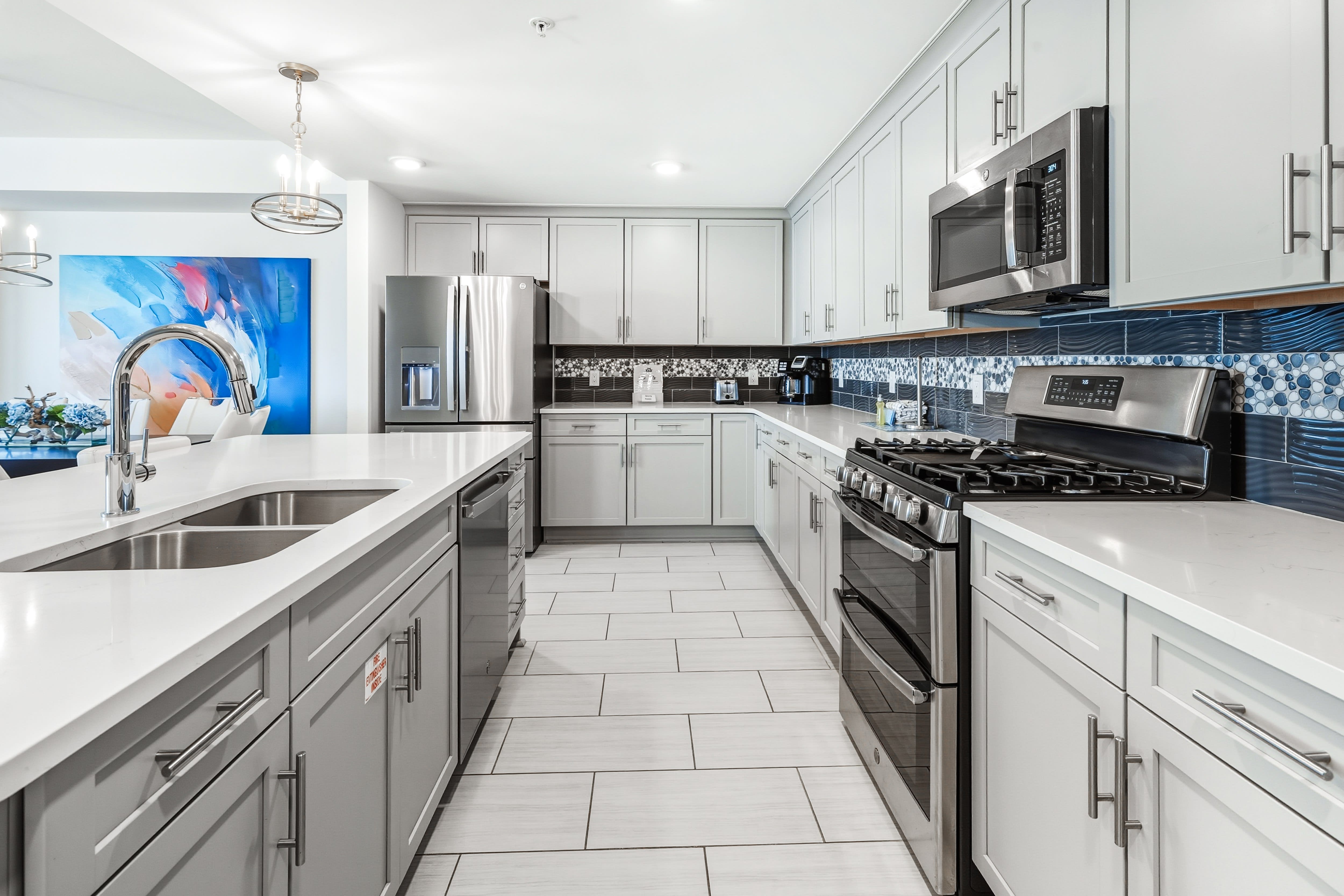 You'll love creating meals in this stunning modern kitchen with sleek white cabinetry, stainless appliances, and beautiful tile backsplash.