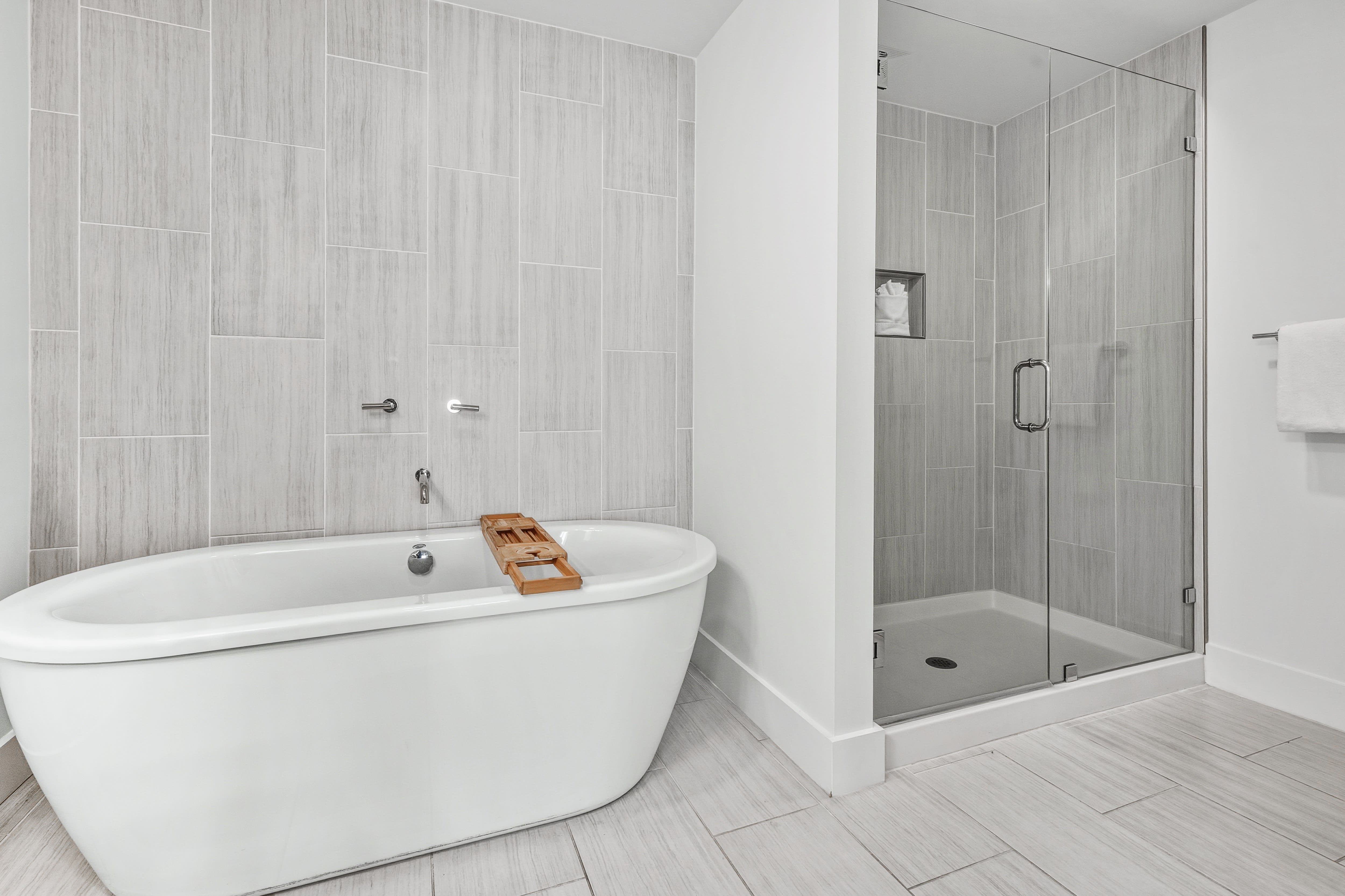 Unwind in your spa-like bathroom with a luxurious soaking tub and modern glass shower, featuring elegant tile work throughout.