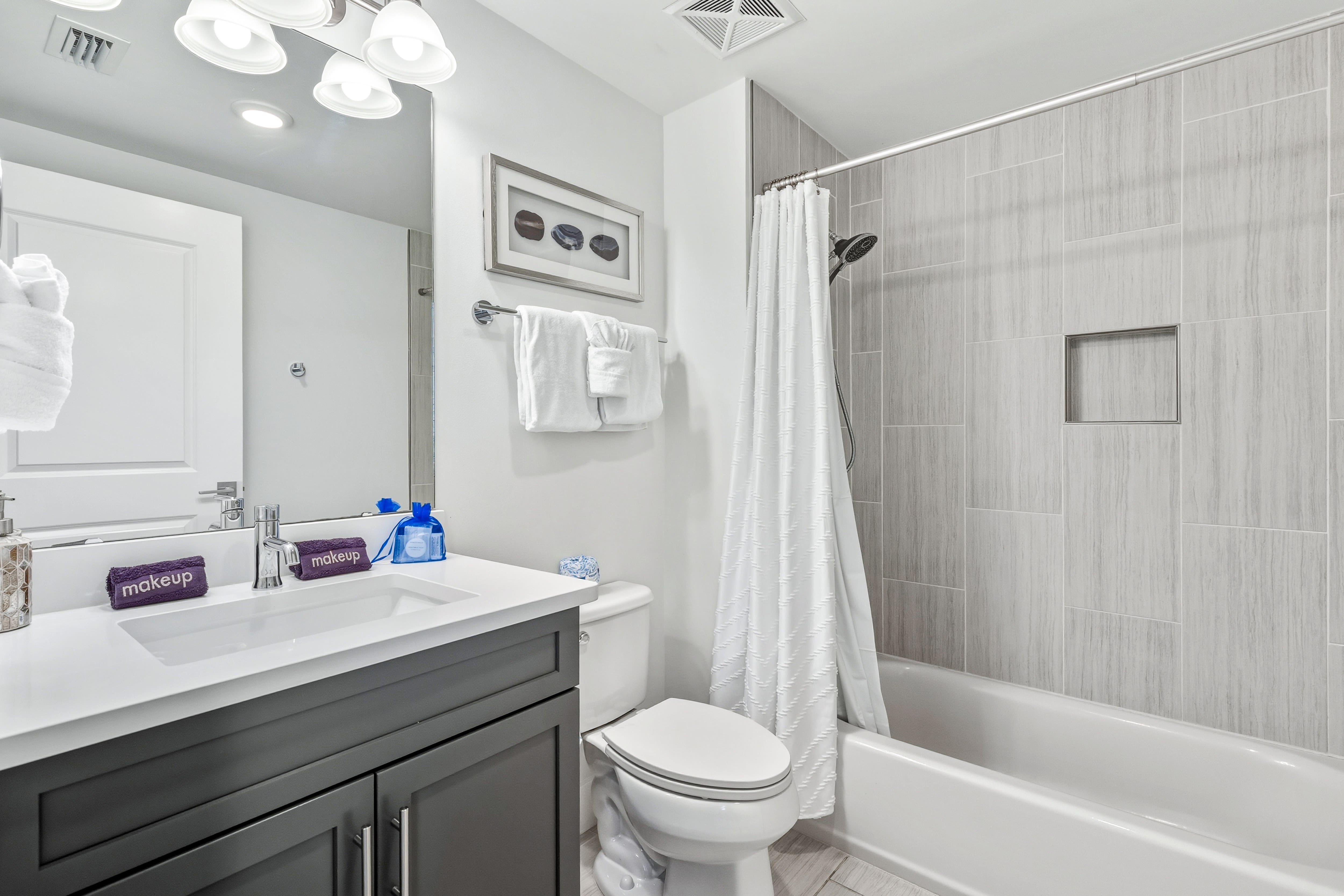 Unwind in your pristine bathroom featuring elegant tiling, modern fixtures, and thoughtful amenities for your comfort.